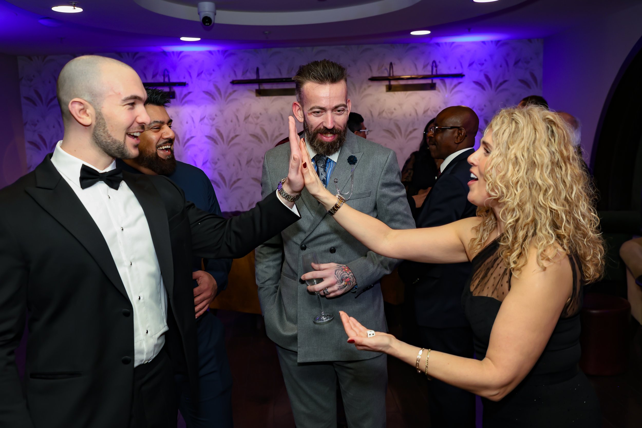 Guests enjoying while engaging magic trick during a corporate function.