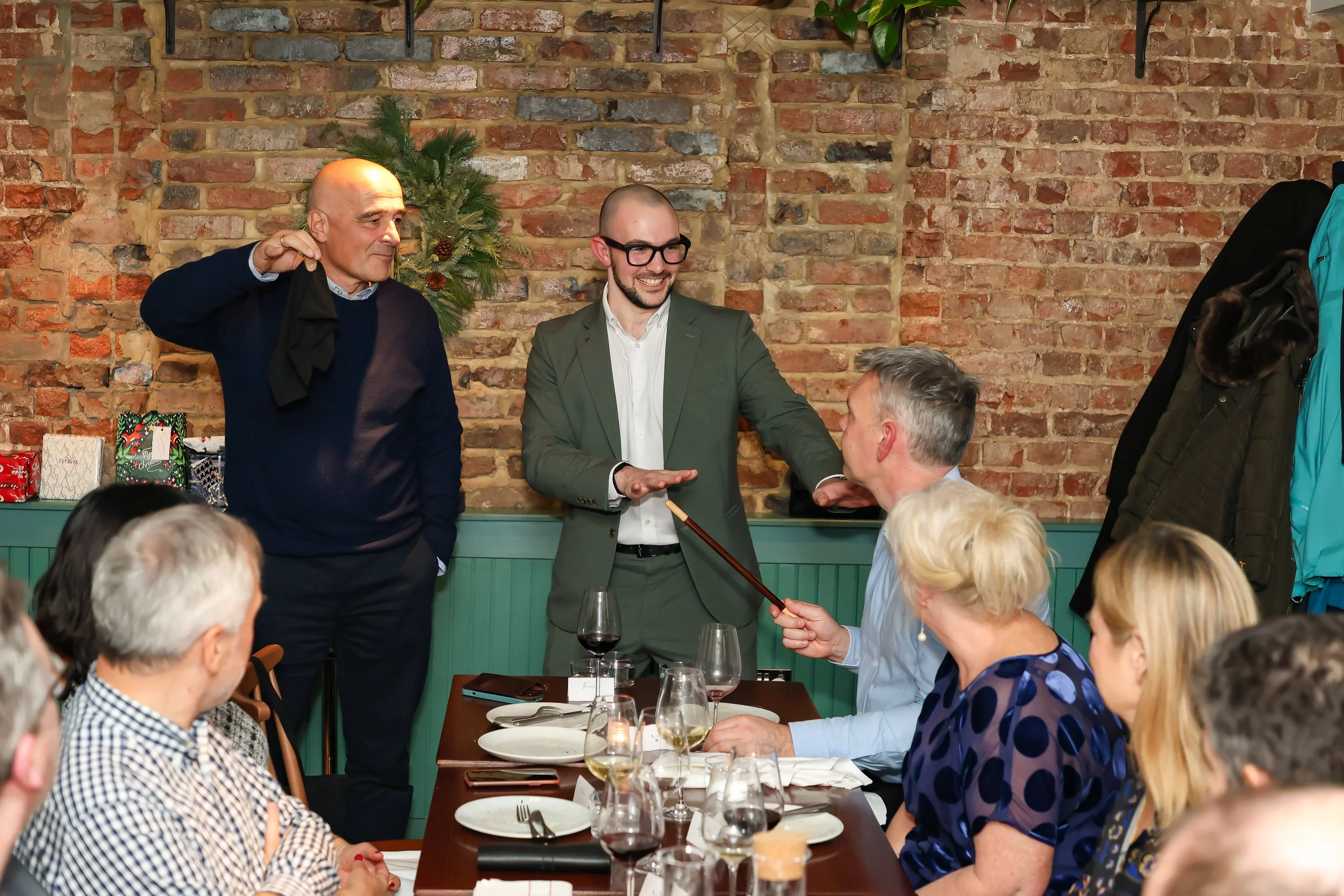 Magician performing close-up magic and involving guests during a corporate dinner.