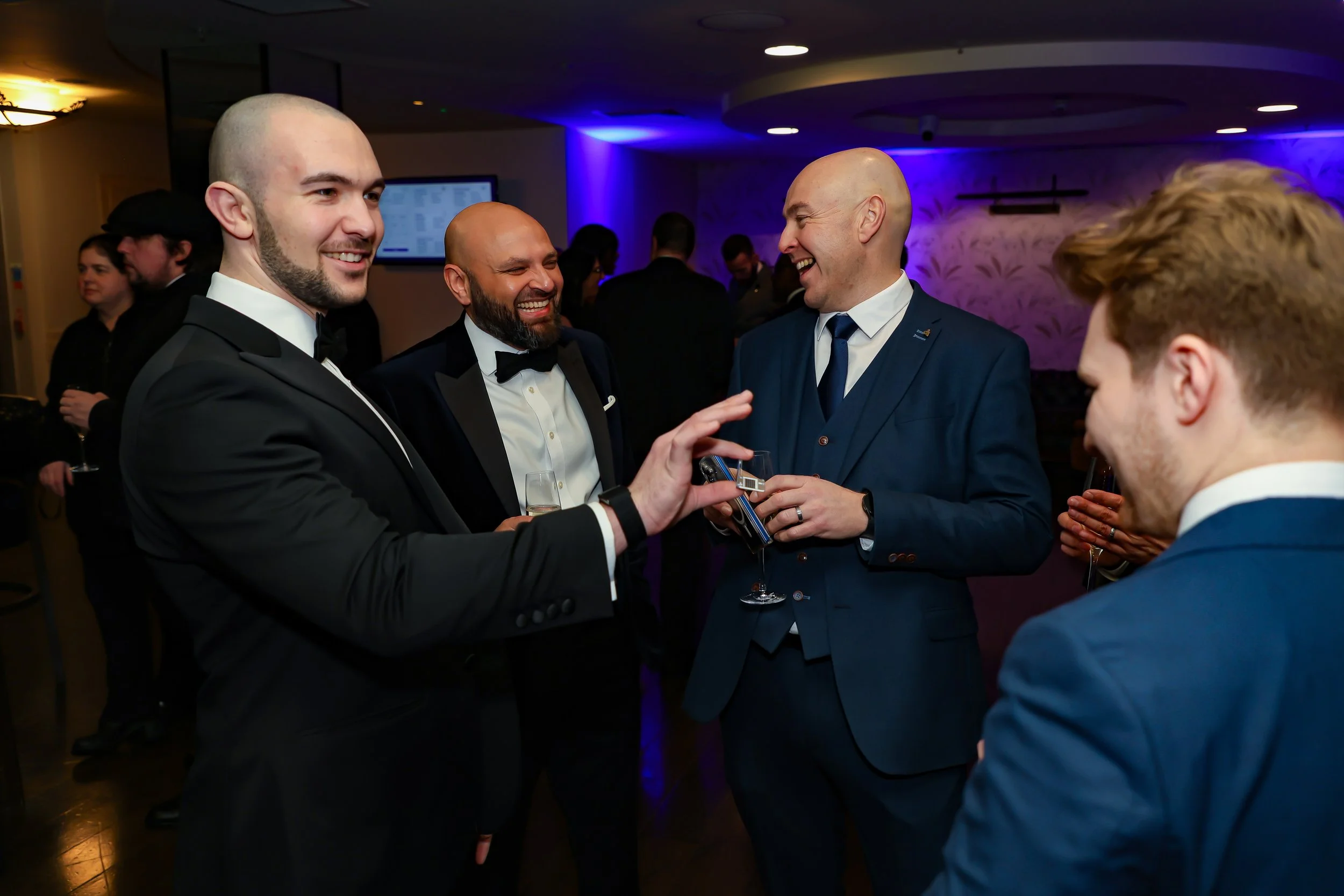 Corporate senior associates watching a magician demonstrate a card illusion.