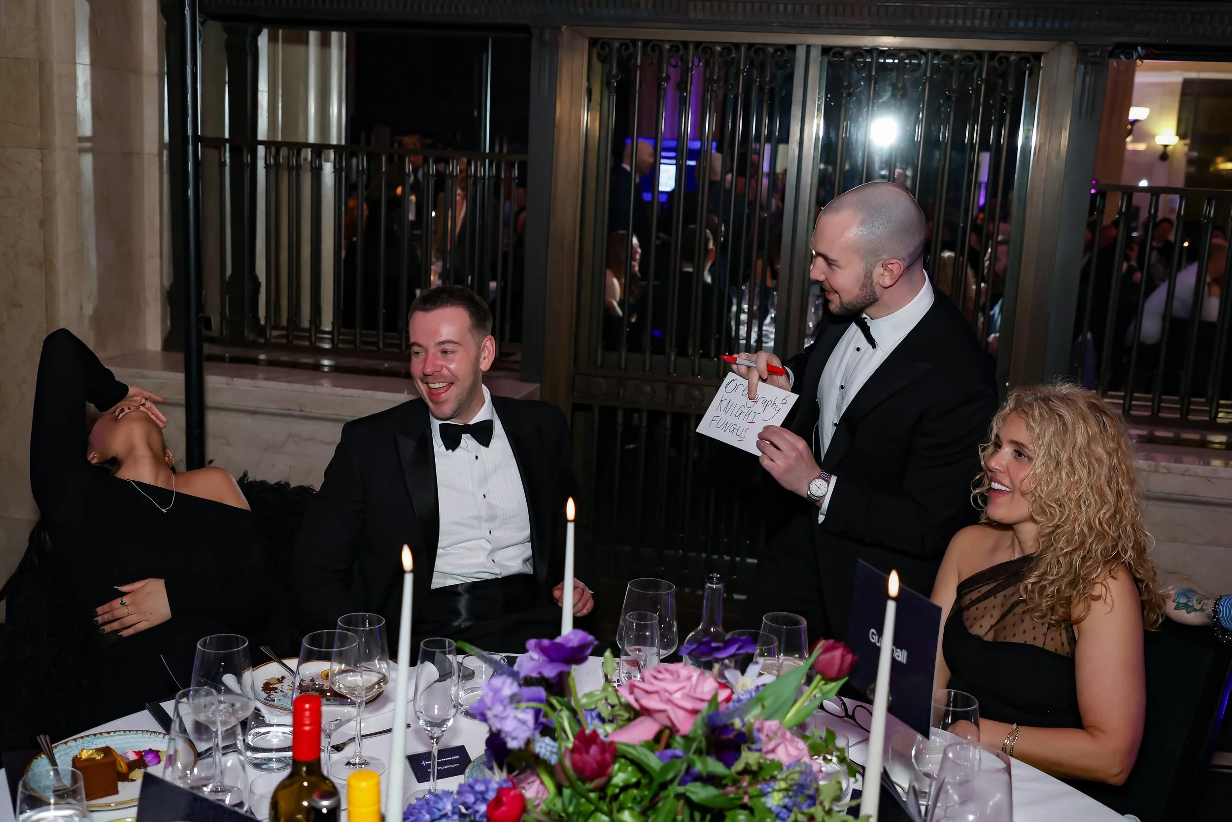 A professional magician delivering table magic during a formal corporate dinner.