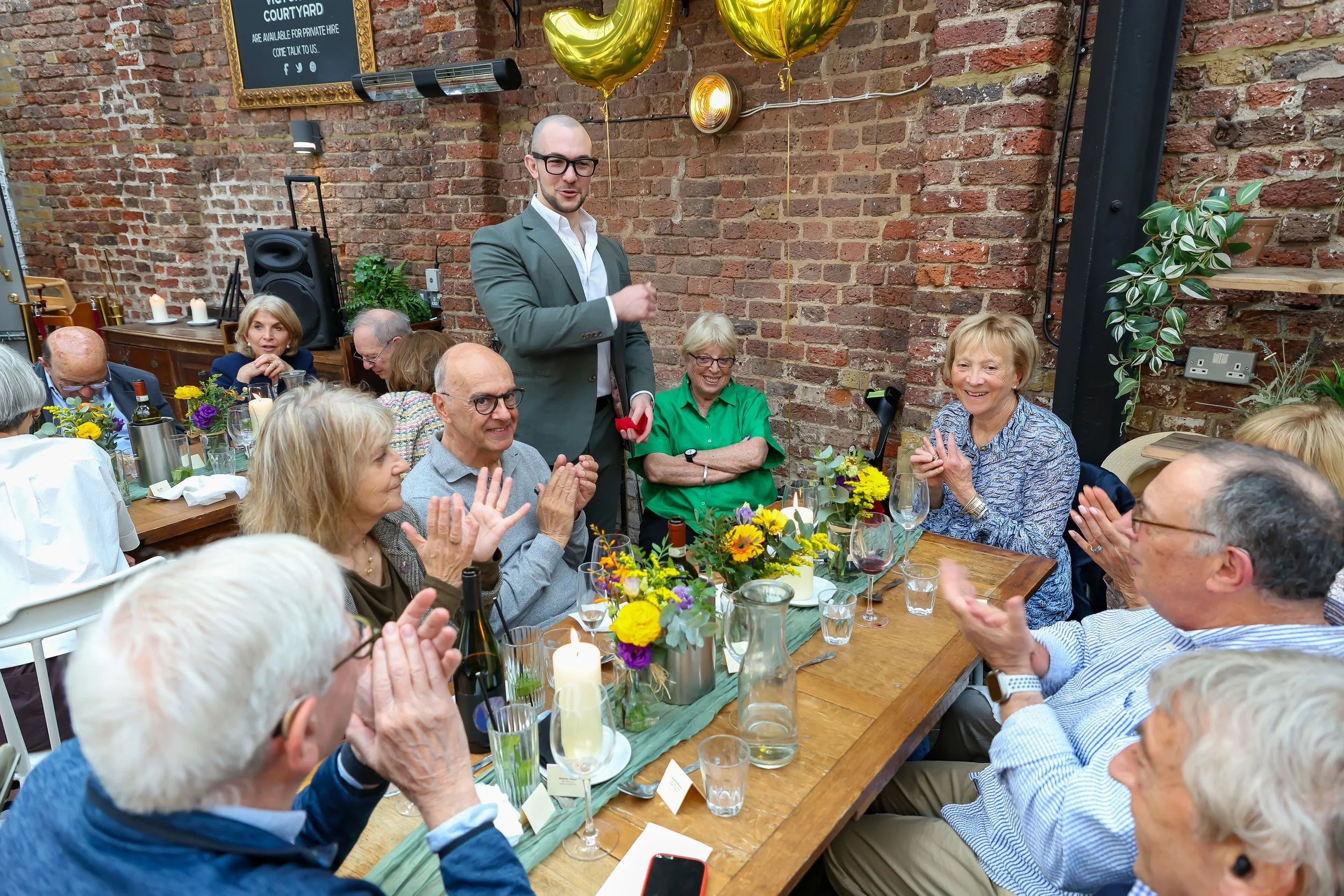 Guests enjoying on Magician mingling tricks. 2026-May 3 Rhoda & Baruch Golden Anniversary. 