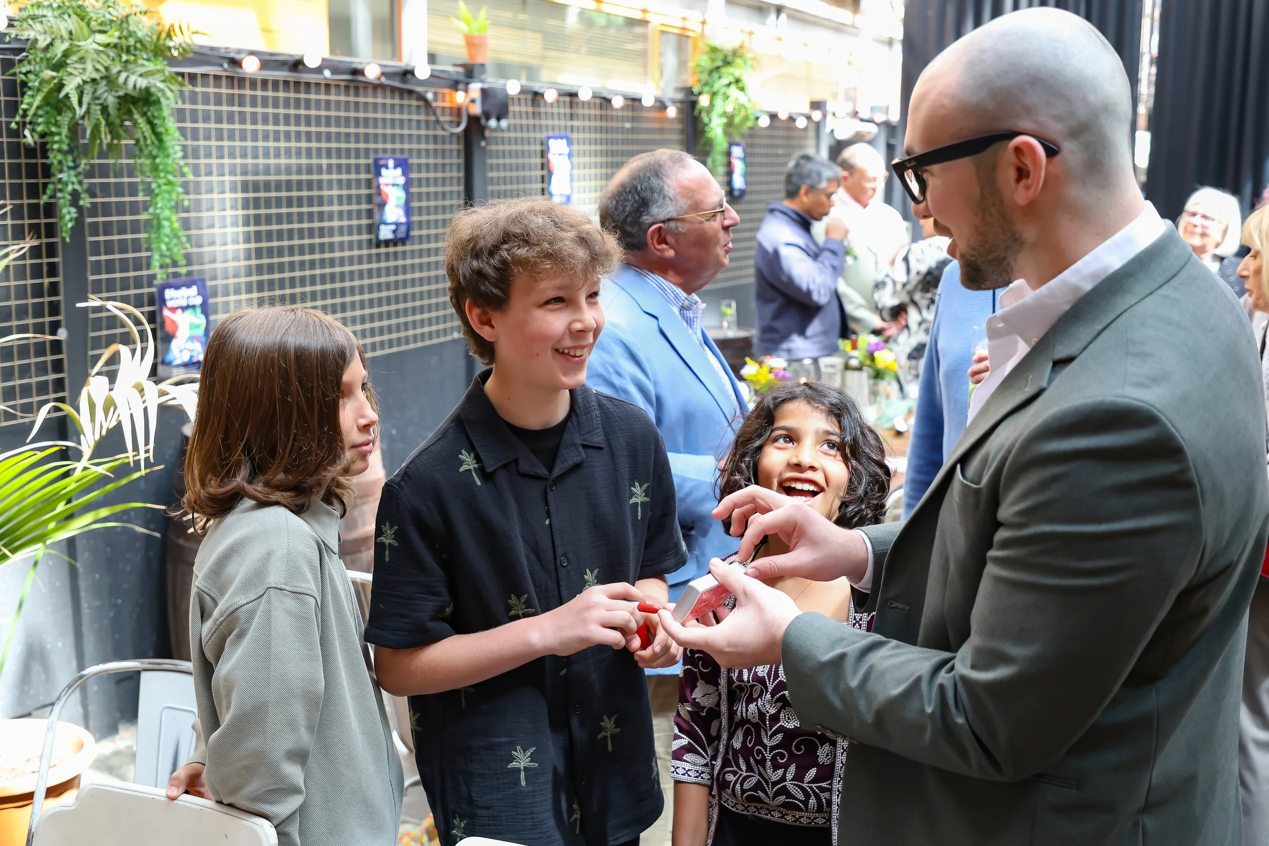 Kids are amazed by the magician cellphone trick. 2026-May 3 Rhoda & Baruch Golden Wedding Anniversary. 