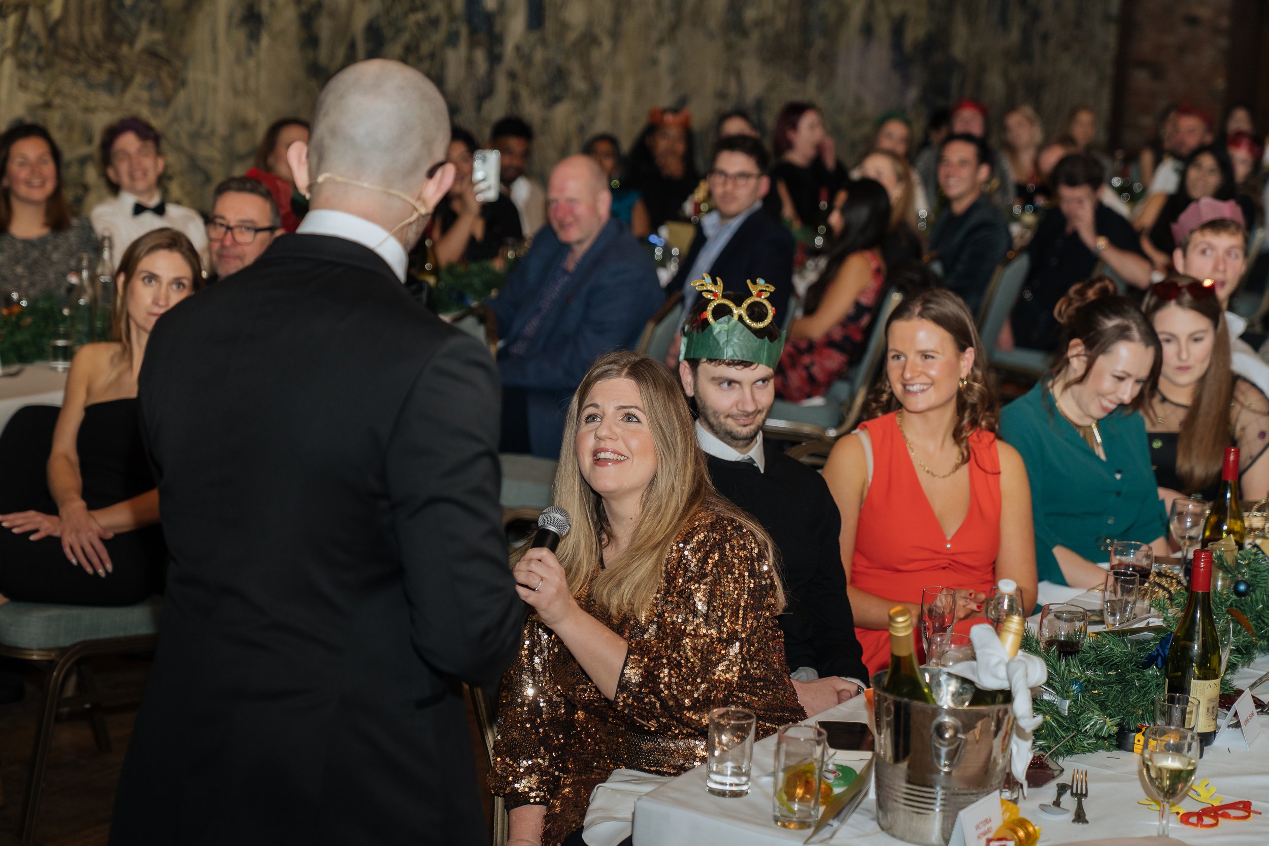 Corporate magician performing table-side magic for guests during a company gala dinner.
