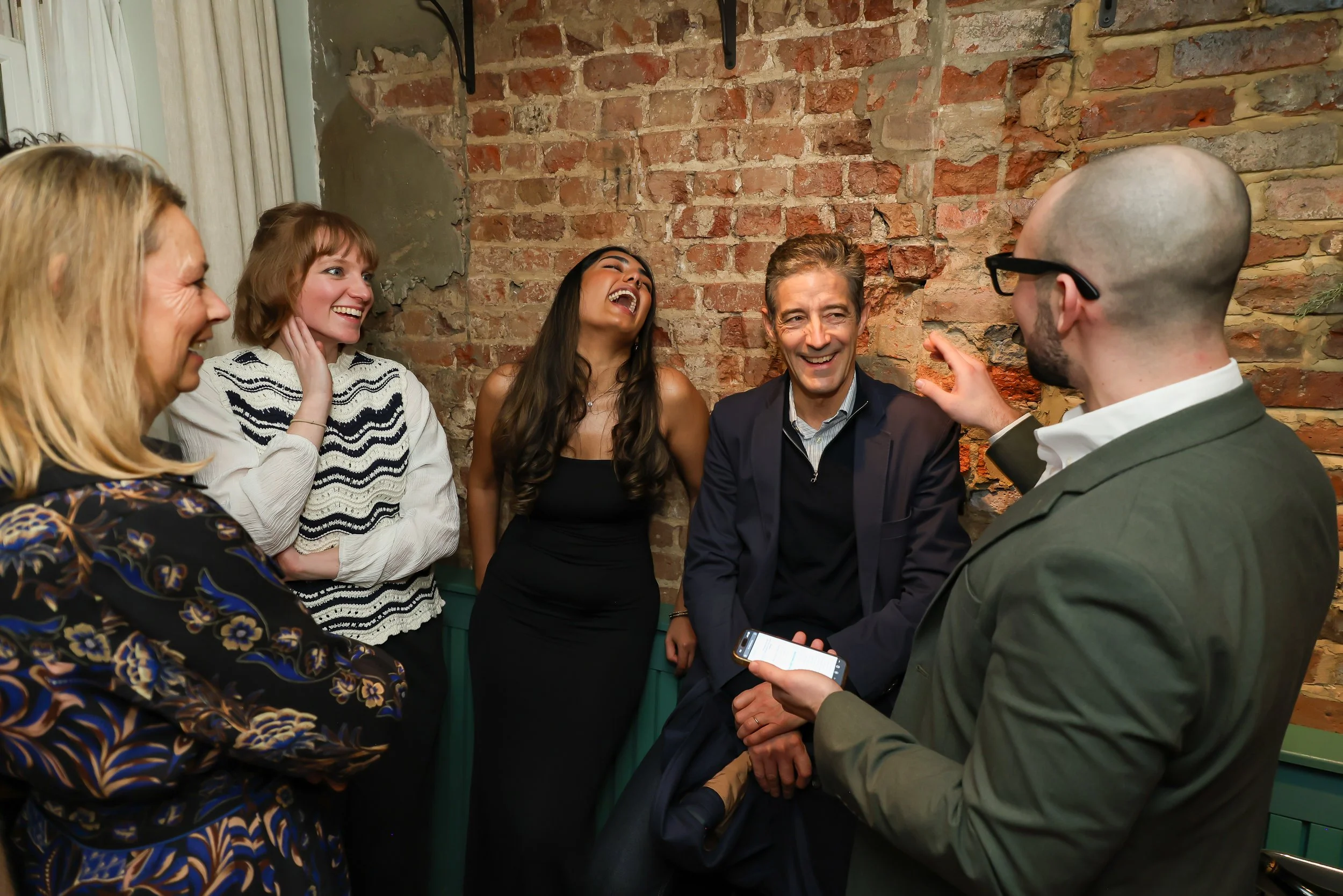 Corporate reception guests showing appreciation for a live magic performance.