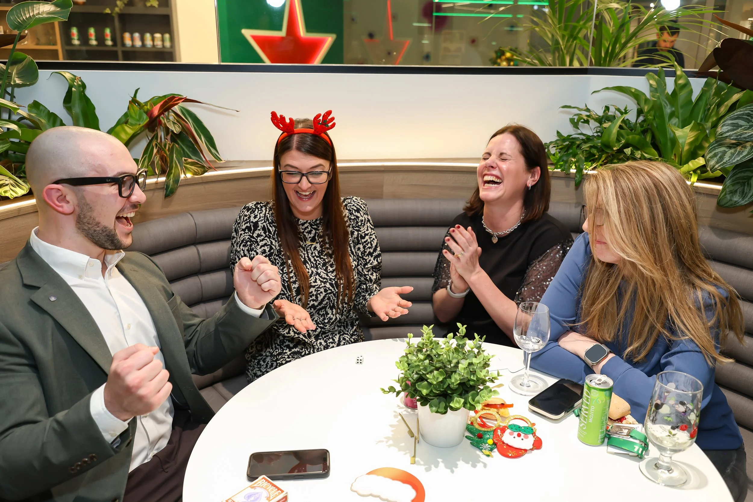Corporate guests react with amazement during a close-up magic performance at a Christmas reception.