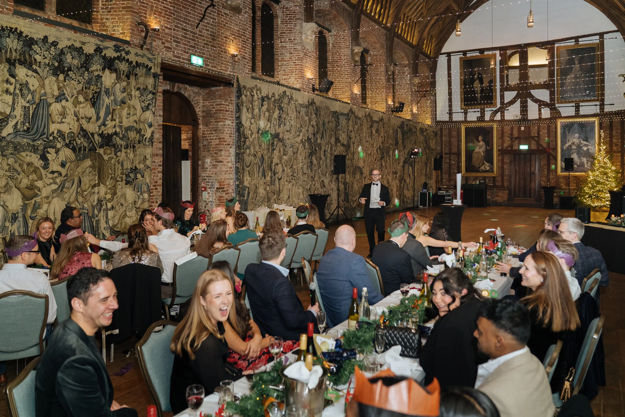 Corporate magician addressing guests with a live performance during a gala dinner.