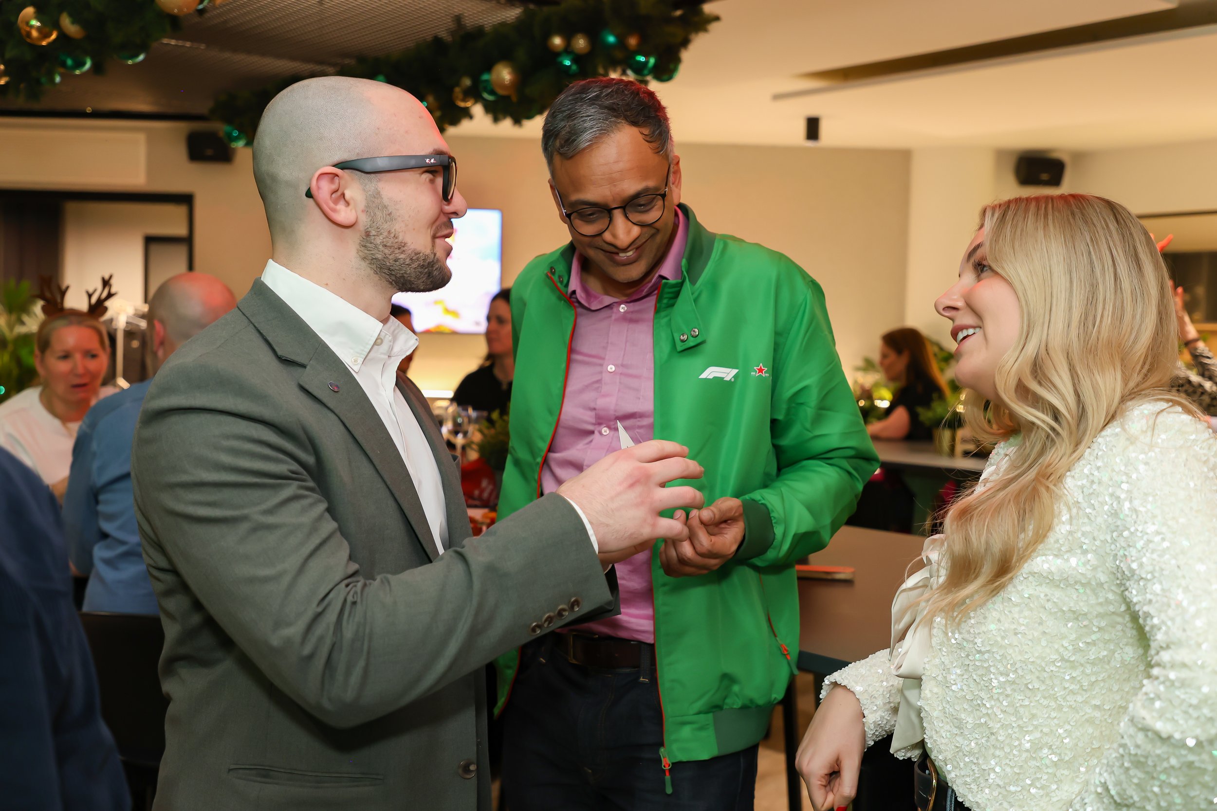 London magician engage with corporate guests during an interactive walk-around at christmas party. 