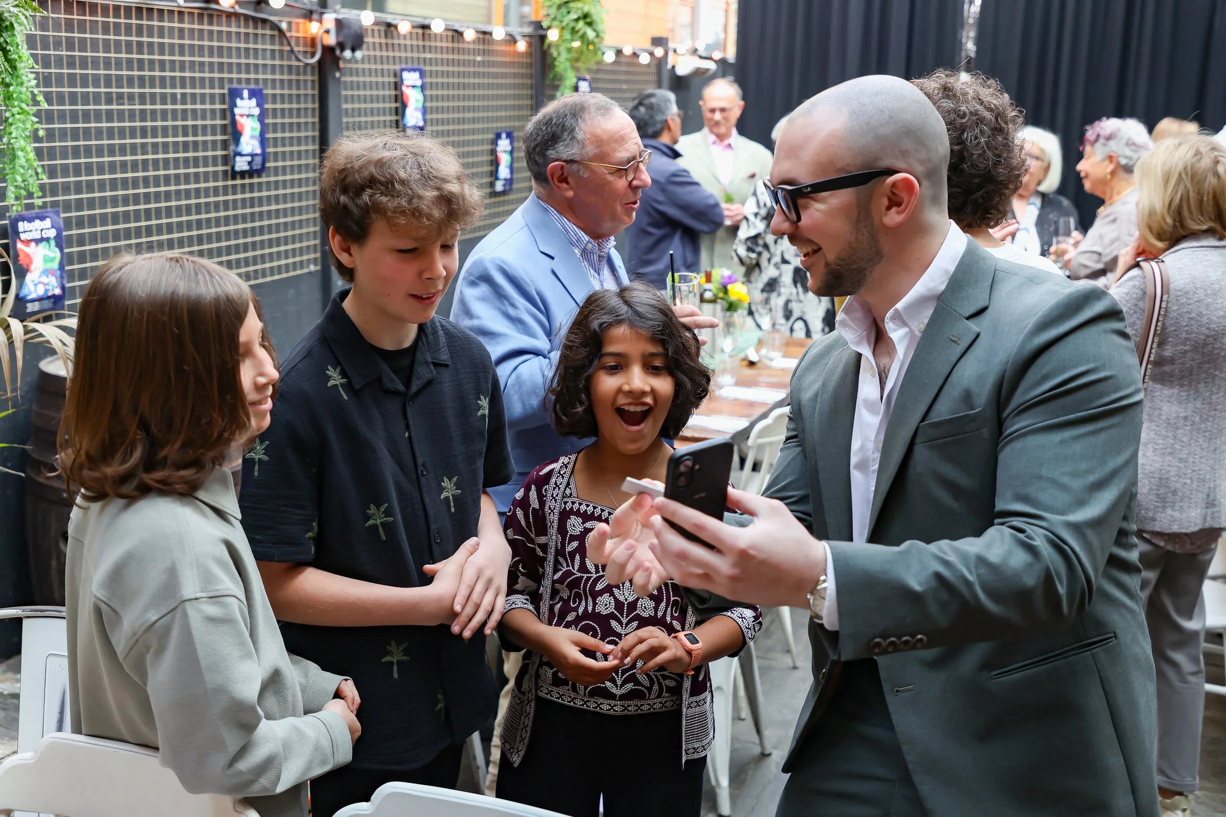 Kids are amazed by the magician cellphone trick. 2026-May 3 Rhoda & Baruch Golden Wedding Anniversary. 