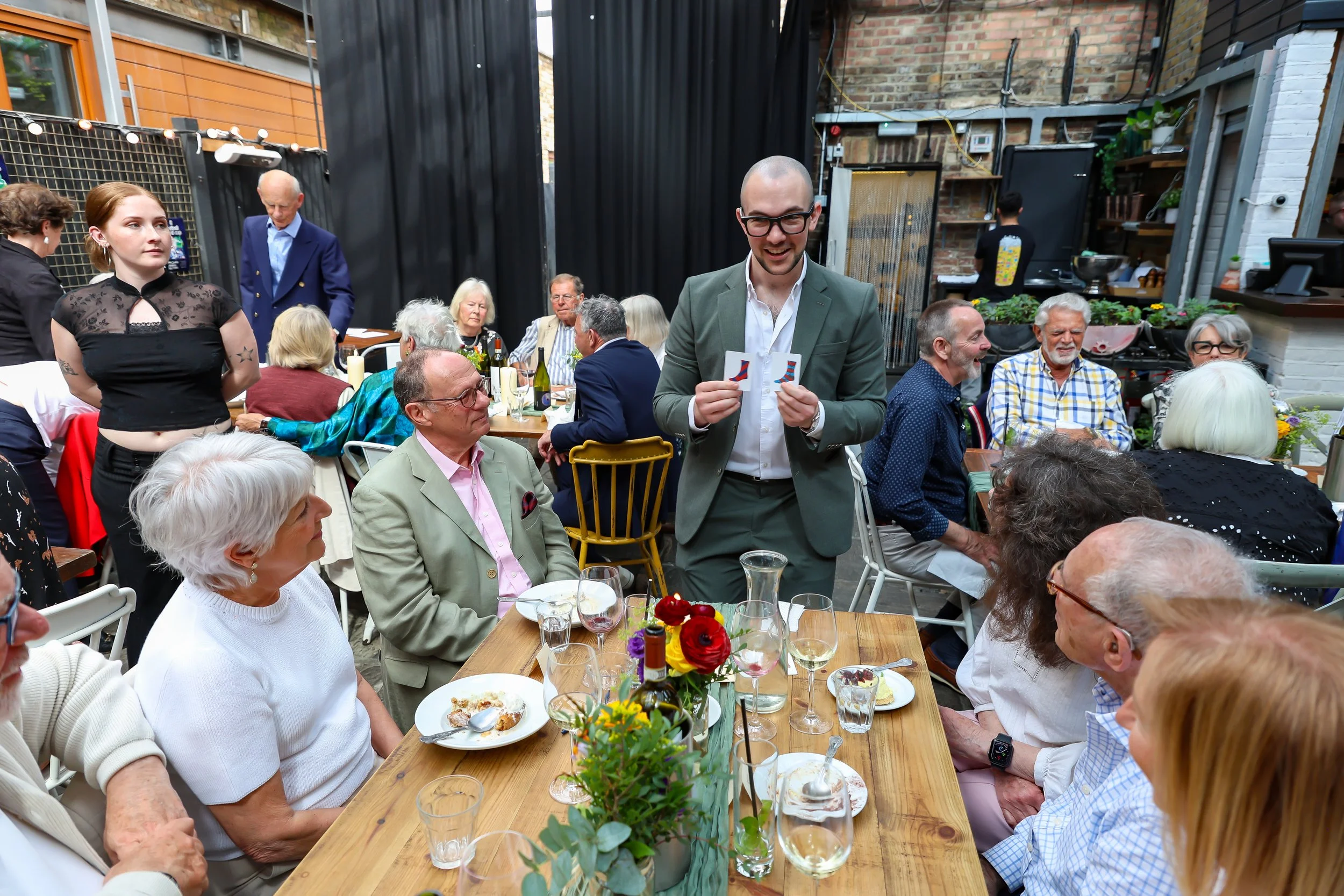 Guests participate with the Magician card tricks. 2026-May 3 Rhoda & Baruch Golden Anniversary. 