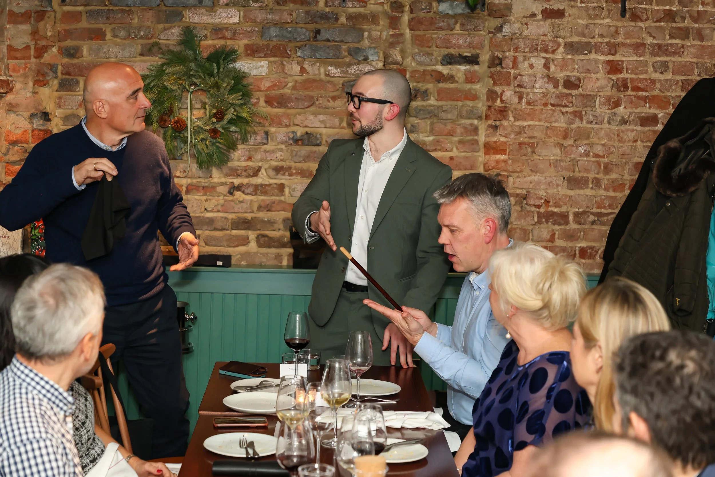 Magician performing close-up magic and involving guests during a corporate dinner.