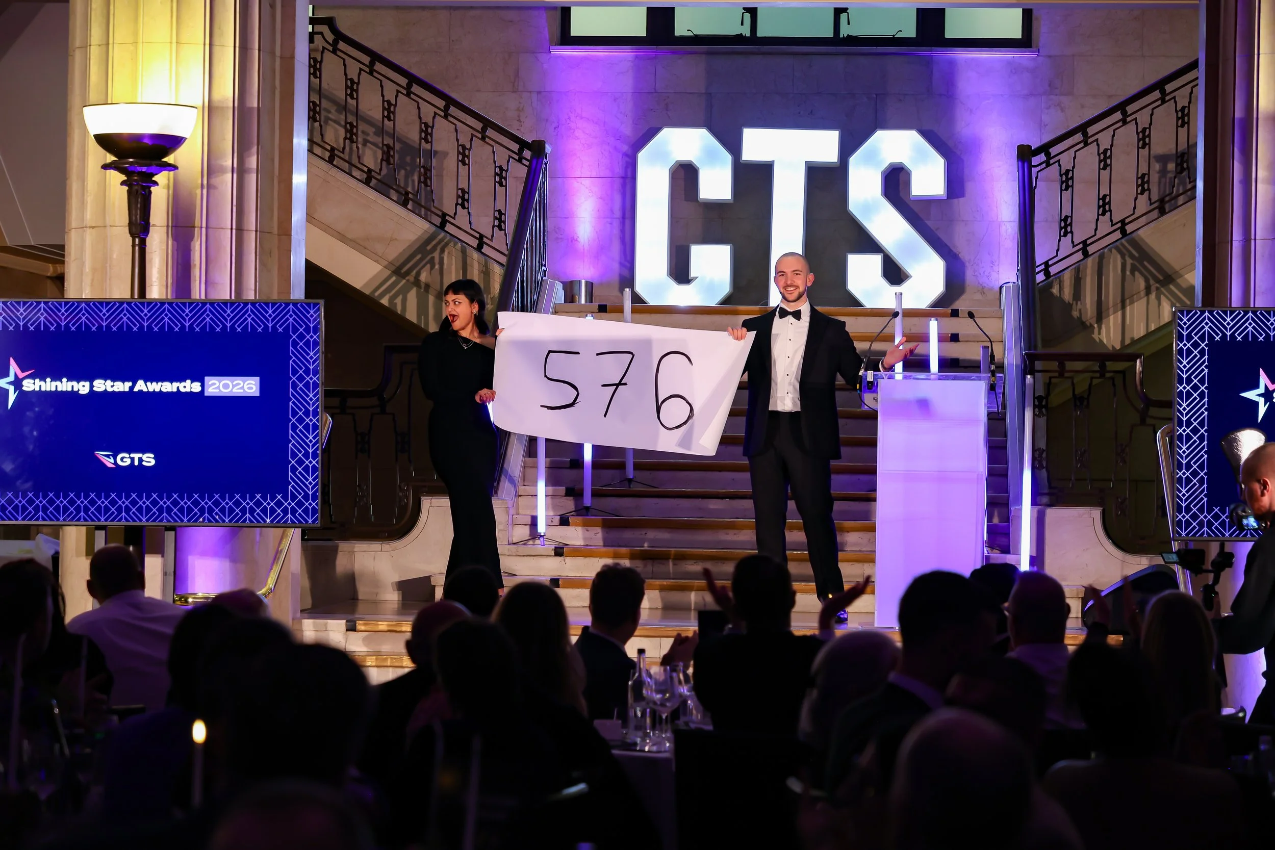 A professional magician involving a guest on stage as the crowd watches in anticipation.