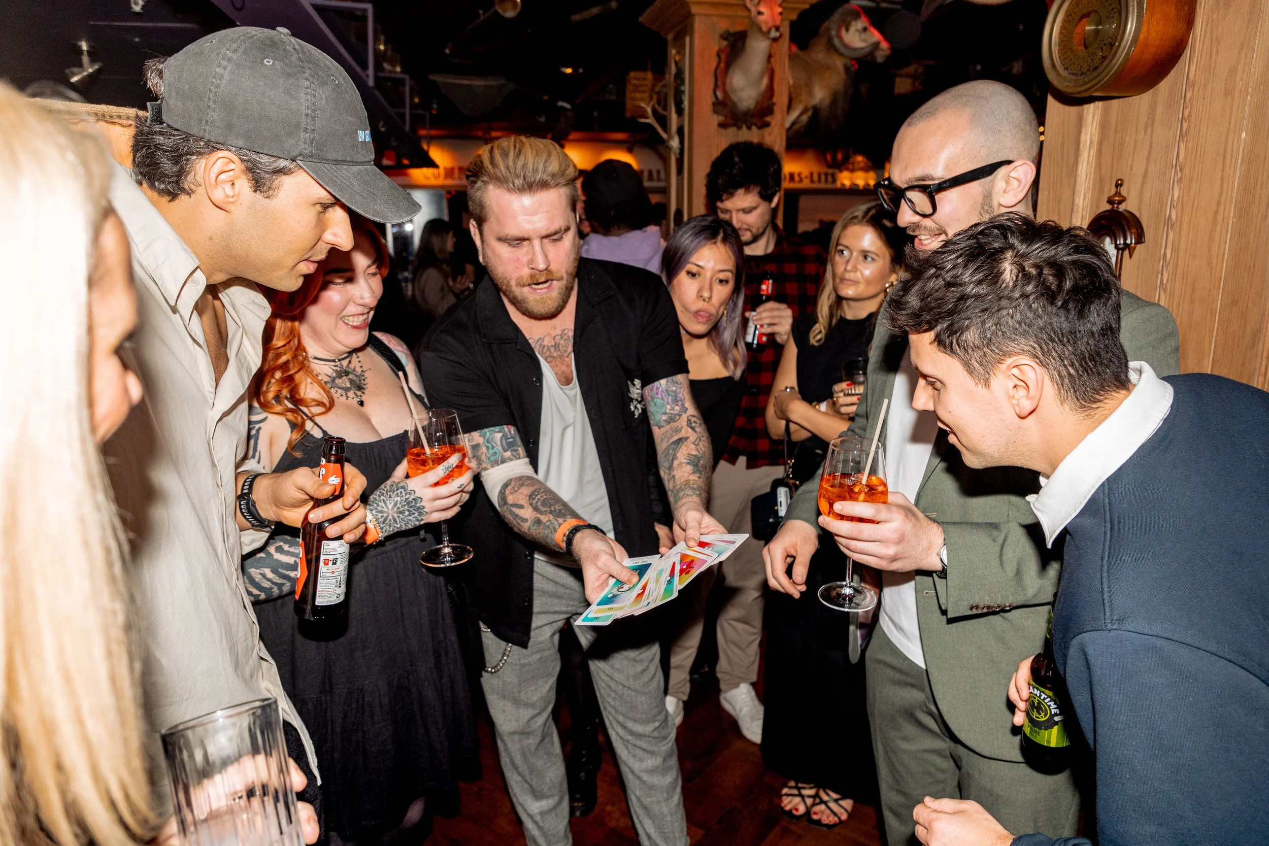 Corporate guests focused on interactive magic performance during event reception. 
