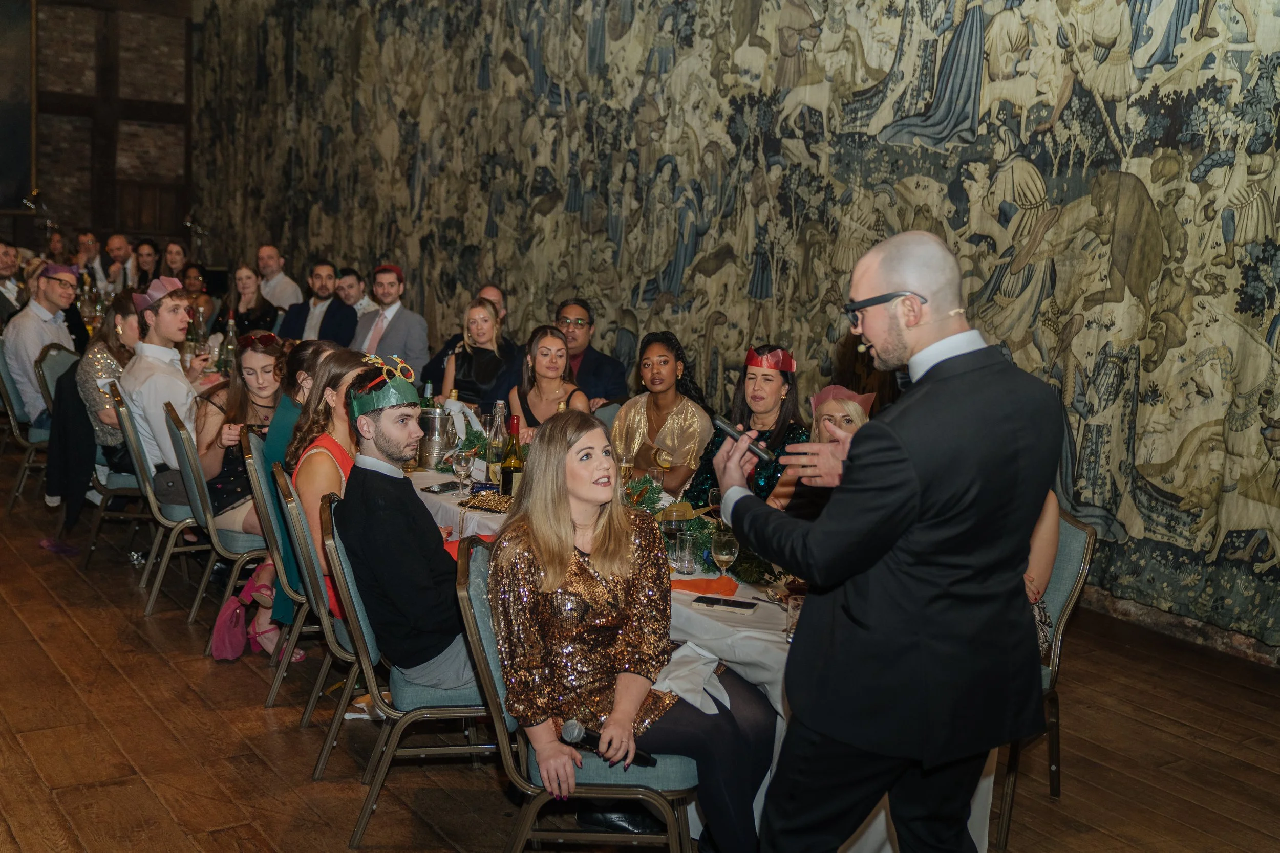 Corporate magician performing table-side magic for guests during a company gala dinner.