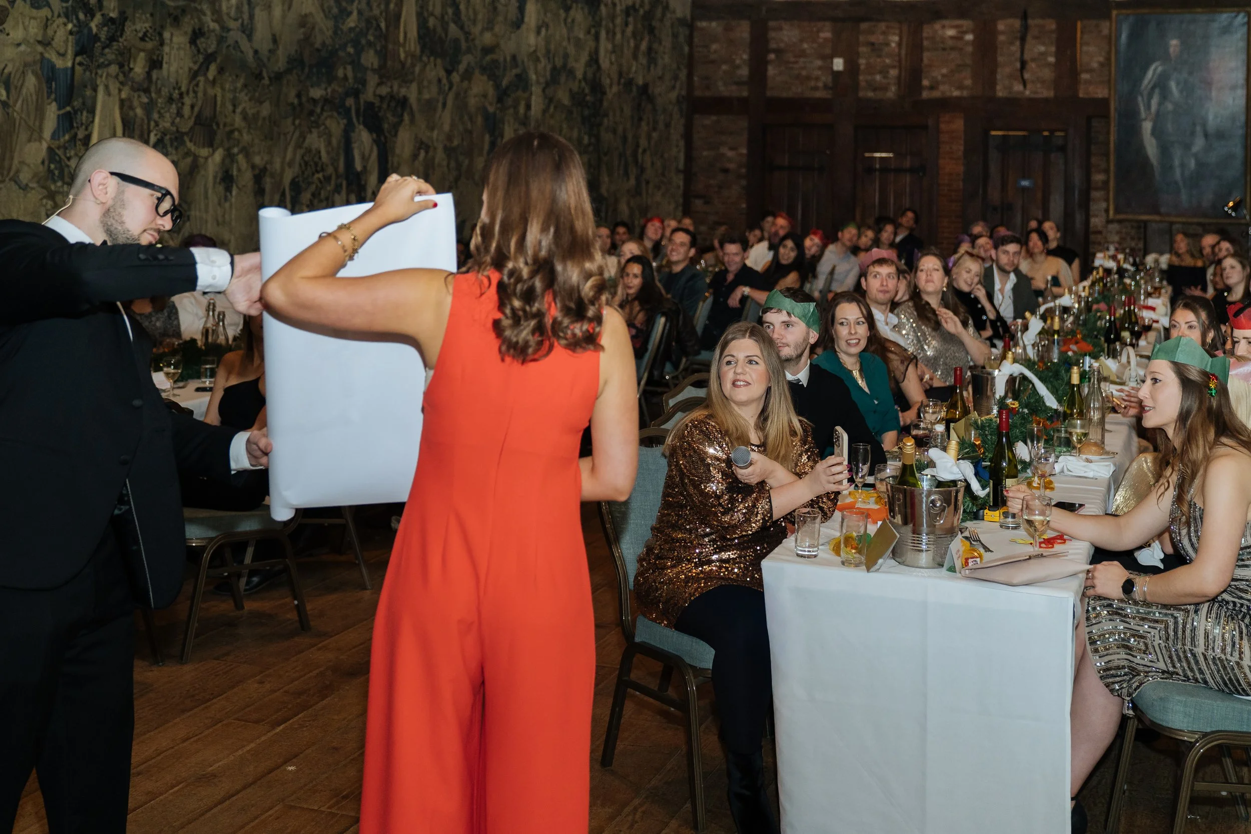 A corporate guest actively participating in a live magic performance, engaging with the magician on stage.