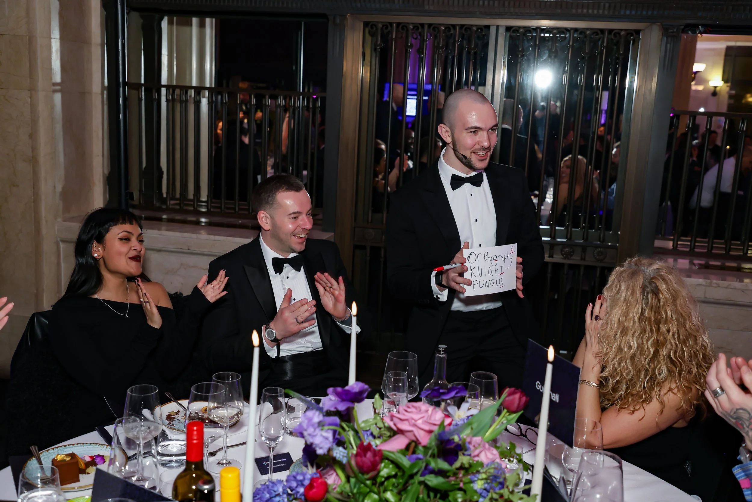 A close-up magician entertaining corporate dinner guests with hands-on magic.