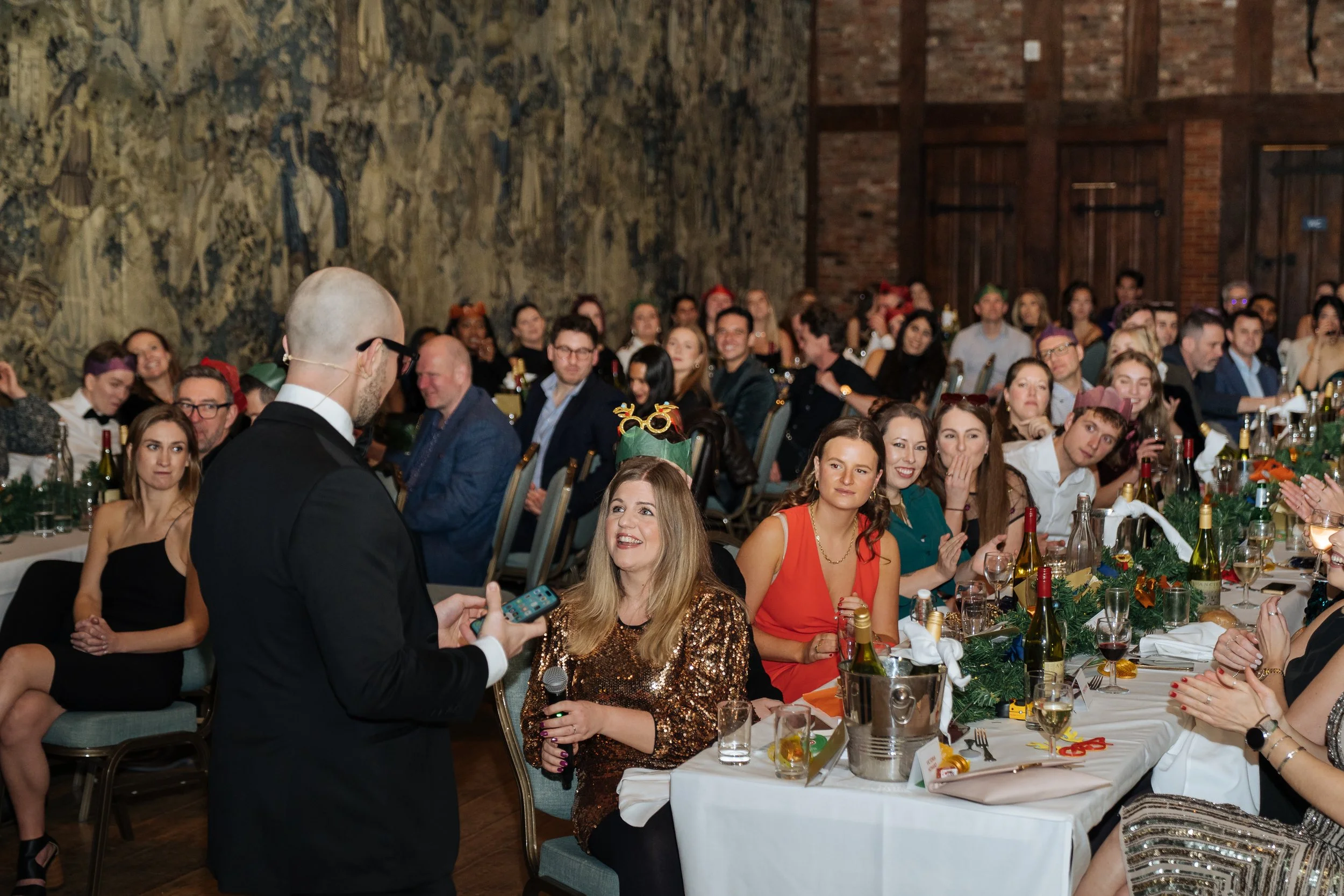 Corporate magician performing table-side magic for guests during a company gala dinner.