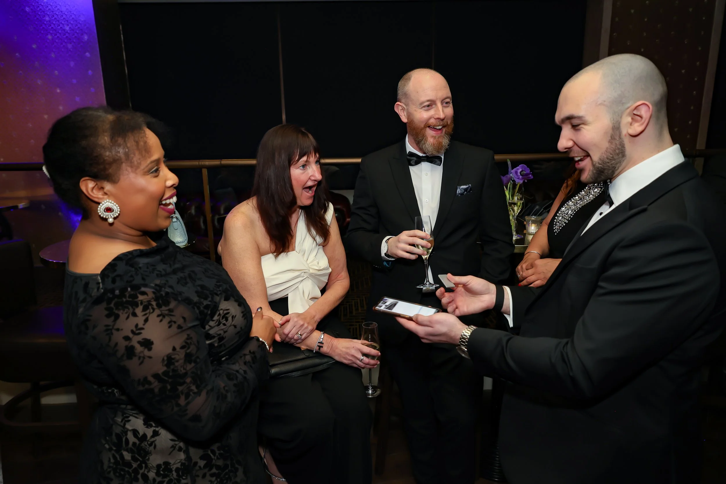 Magician engaging corporate professionals with a live card performance.