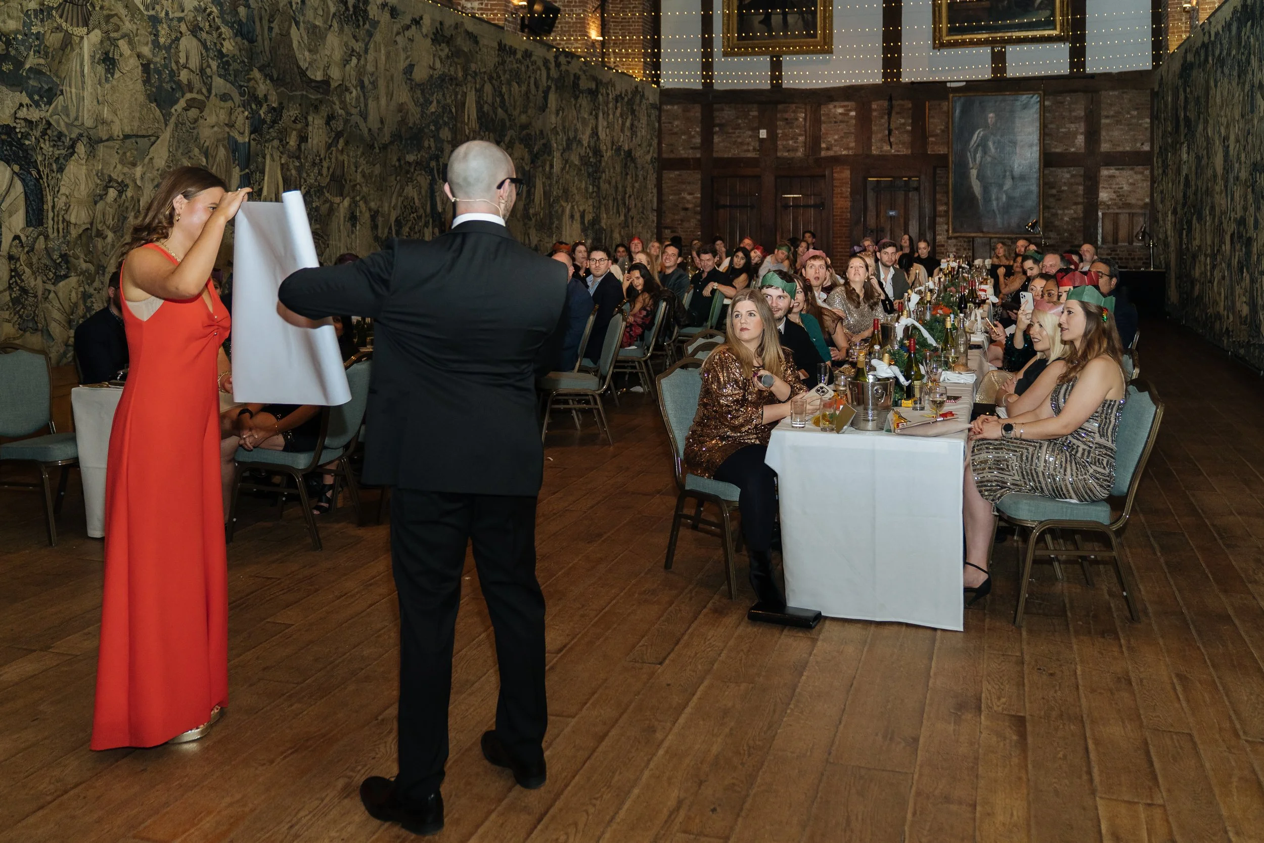 Guest assisting magician during interactive stage magic at corporate party.
