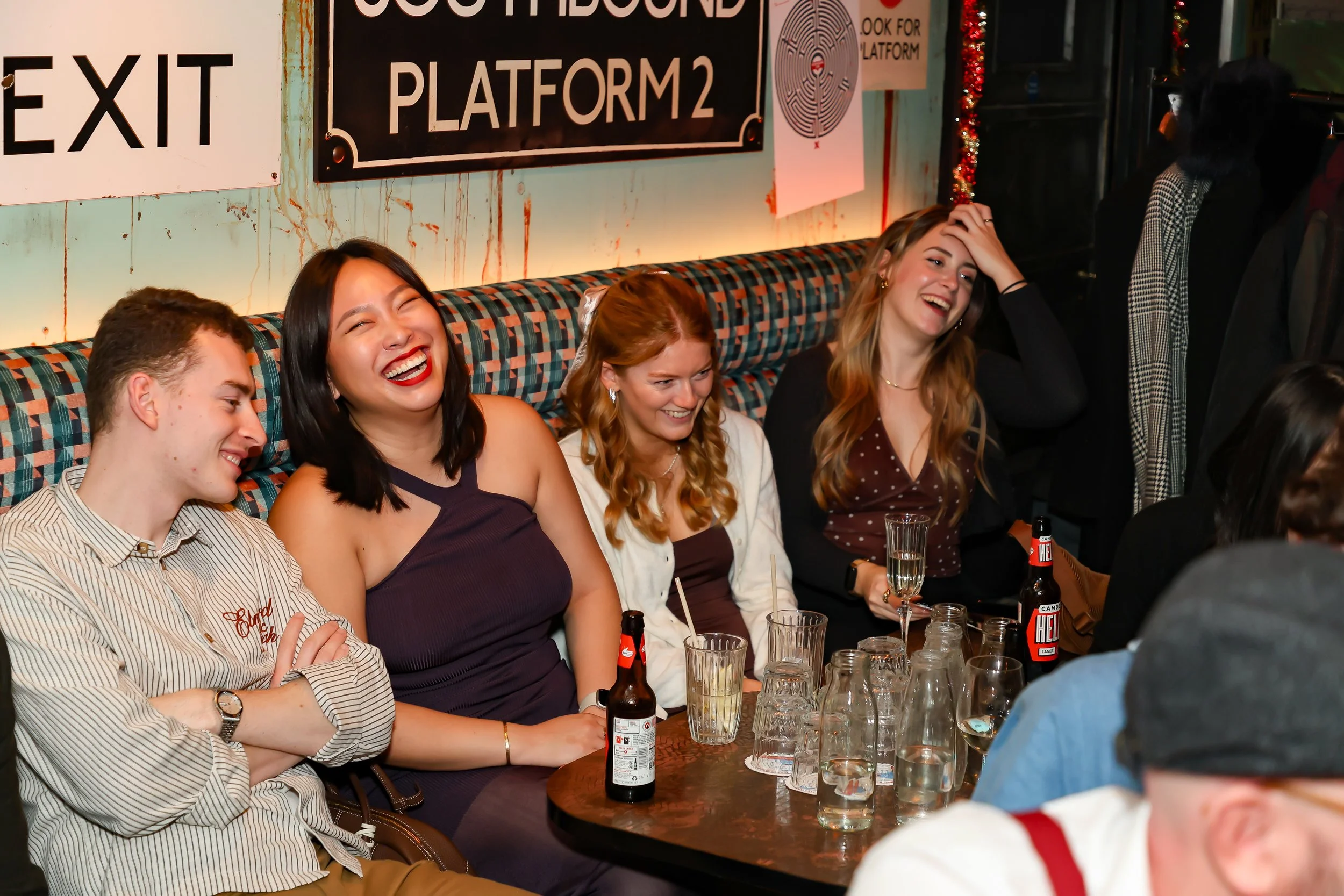 Corporate guests seated and laughing while watching a live magic performance.