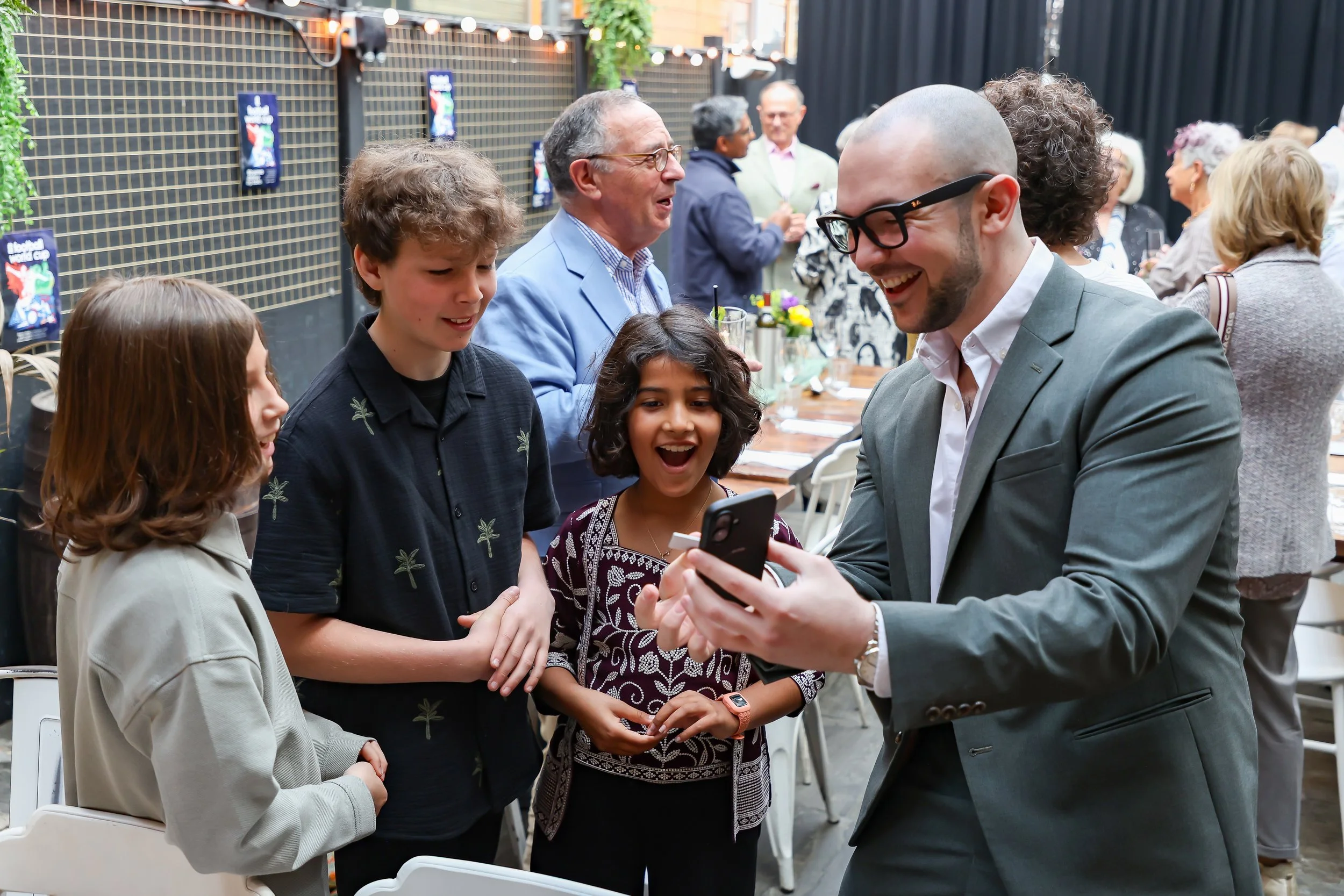 Kids are amazed by the magician cellphone trick. 2026-May 3 Rhoda & Baruch Golden Wedding Anniversary. 