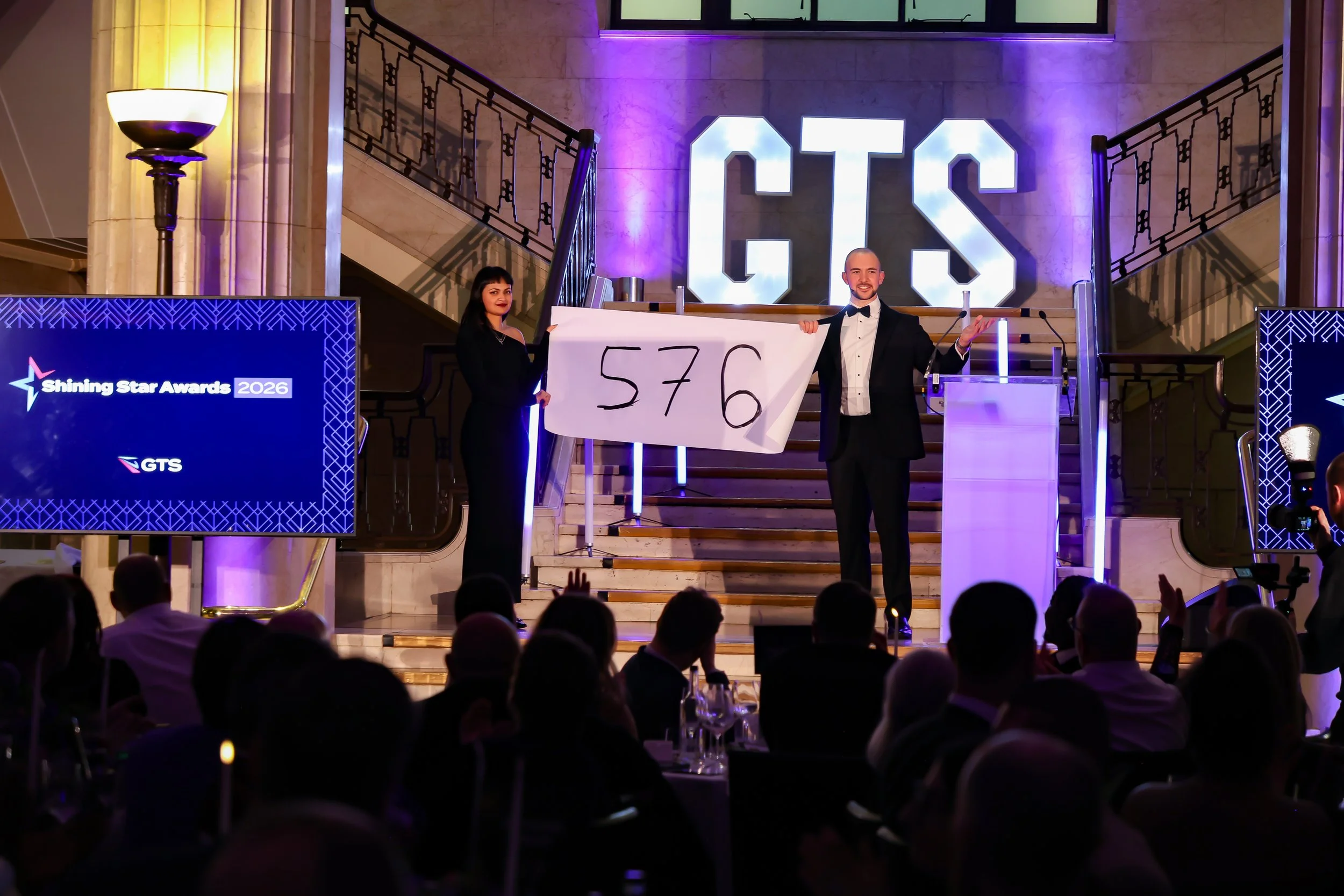 A magician engaging a guest on stage, creating a shared moment of wonder for the audience.