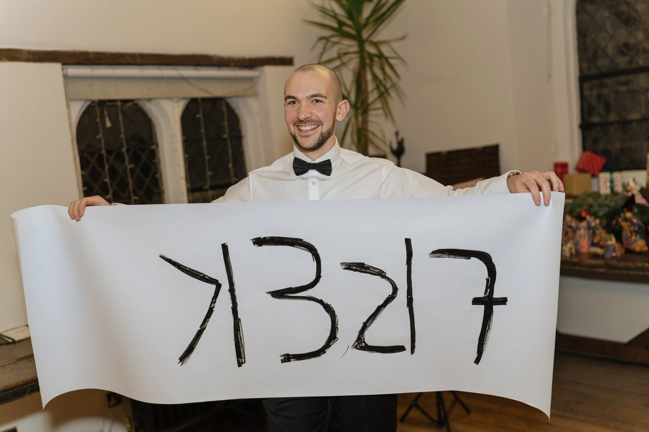 Professional magician presenting a completed magic effect during a formal reception.