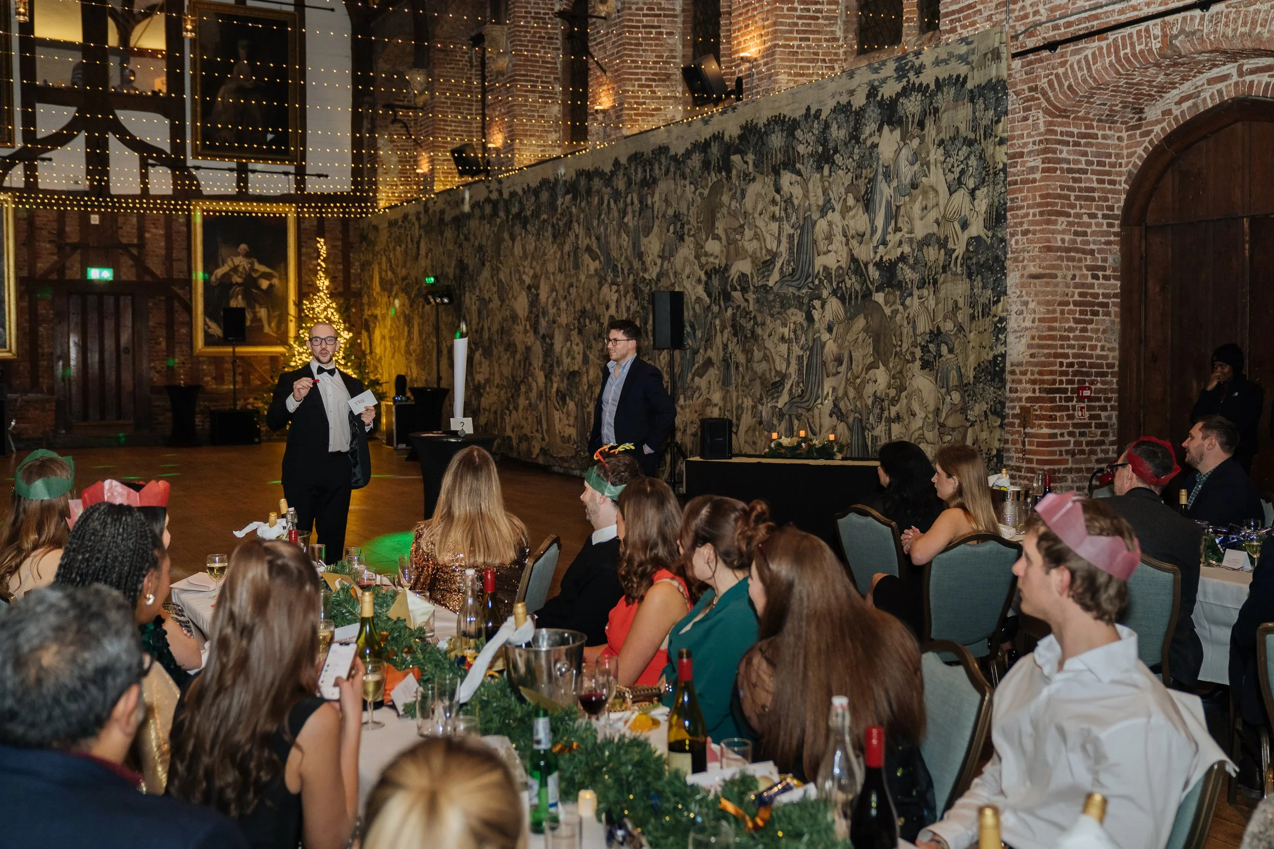 Professional magician engaging a seated corporate audience during a formal dinner.