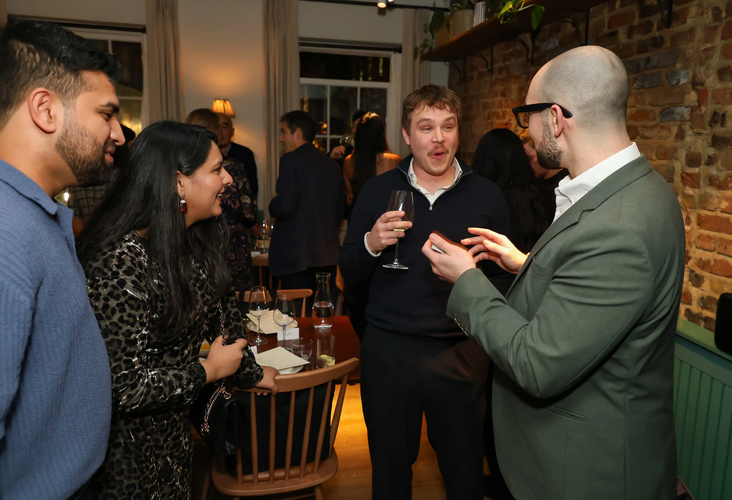 Corporate guests amazed by a live magic trick at a London corporate party.