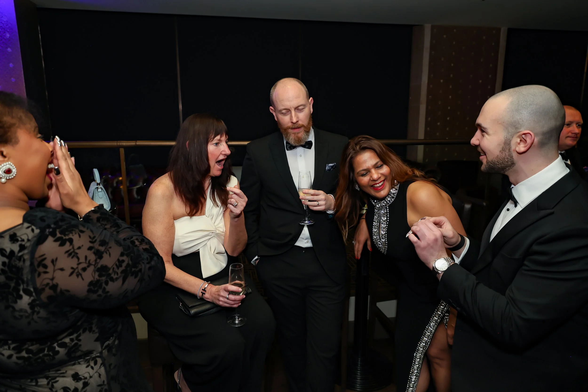 Corporate professionals enjoying with a live card performance by the magician during reception.