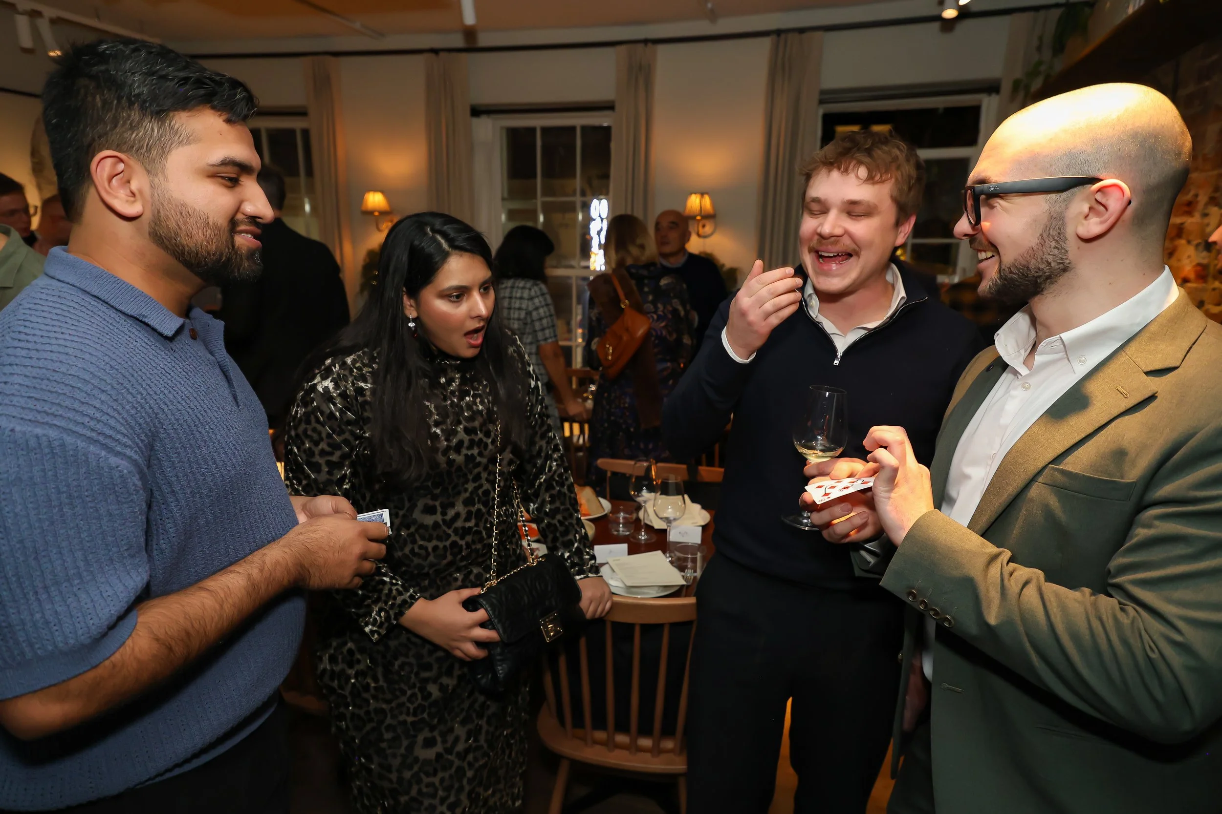 Audience reactions of surprise at a London-based corporate magic performance.