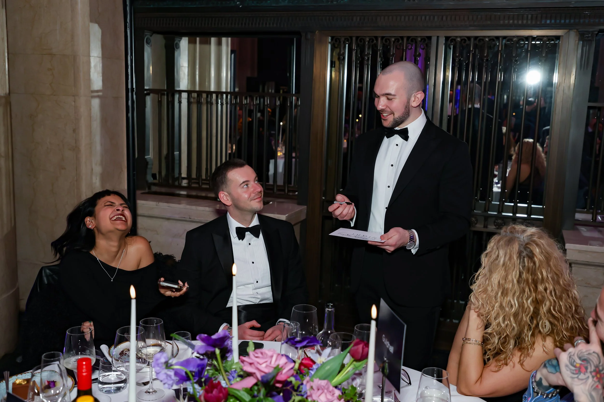 A professional magician delivering table magic during a formal corporate dinner.