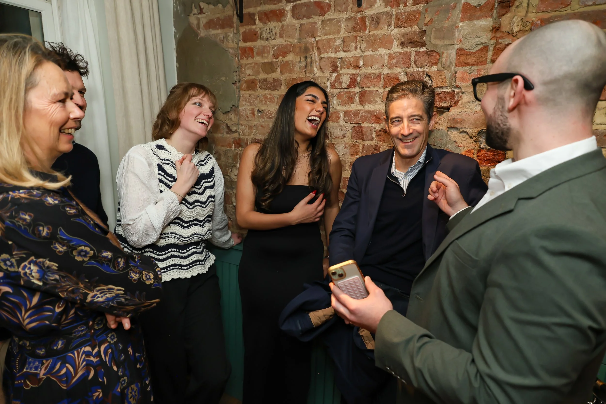 Guests celebrating a successful magic performance during a corporate reception.