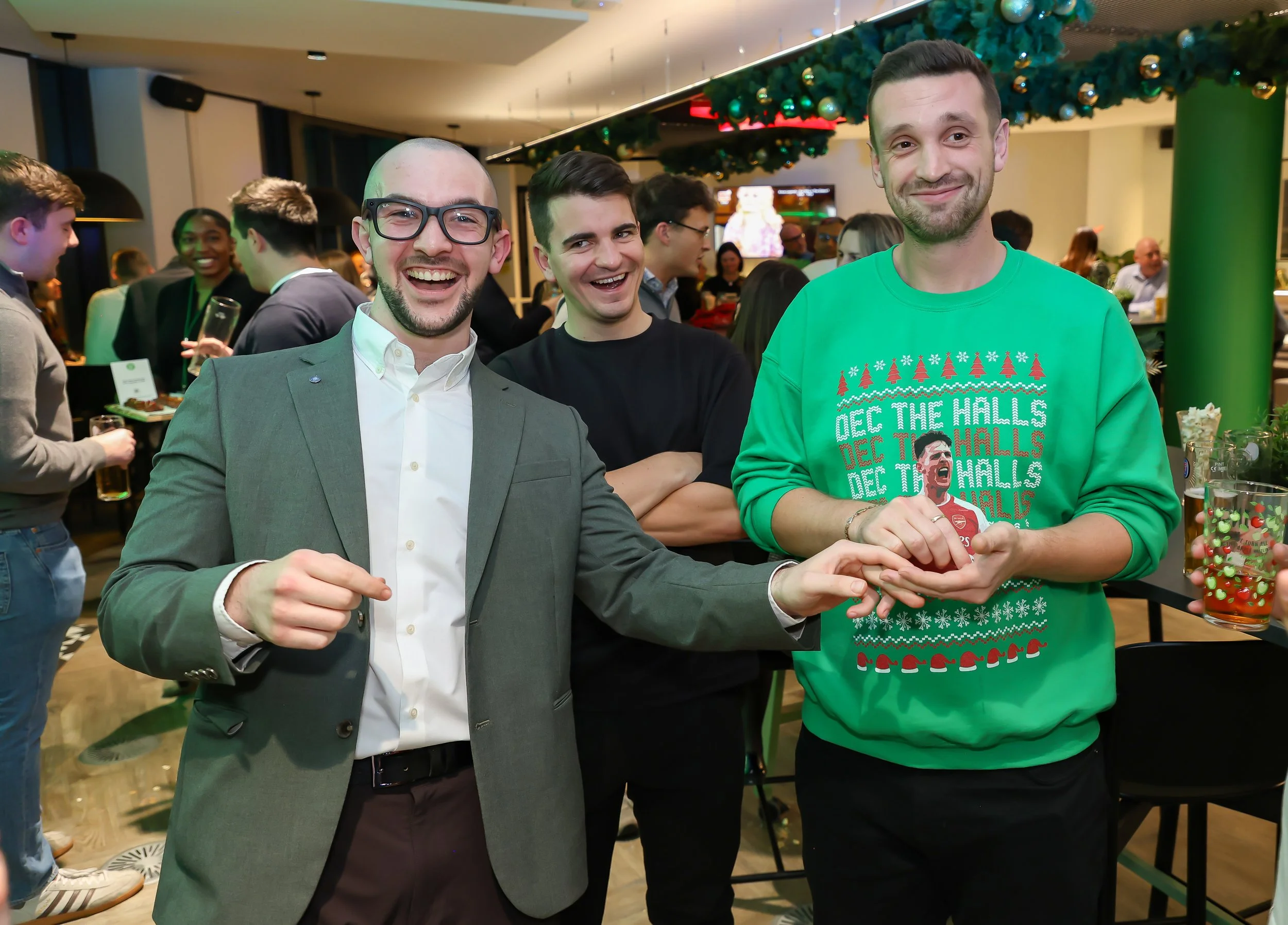 Guests smiling and engaging with the magician in a playful photo moment at the event reception.