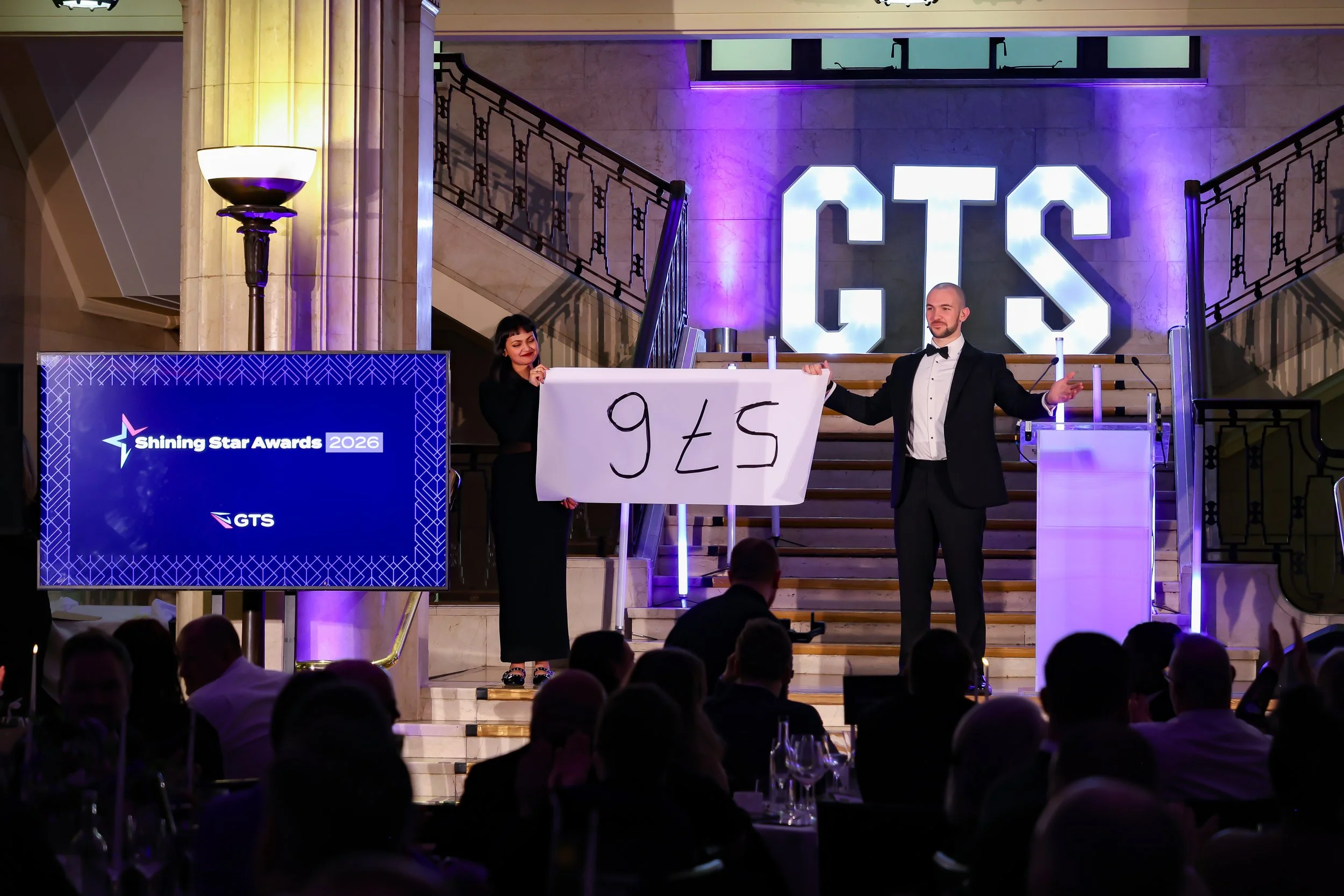 A professional magician involving a guest on stage as the crowd watches in anticipation.