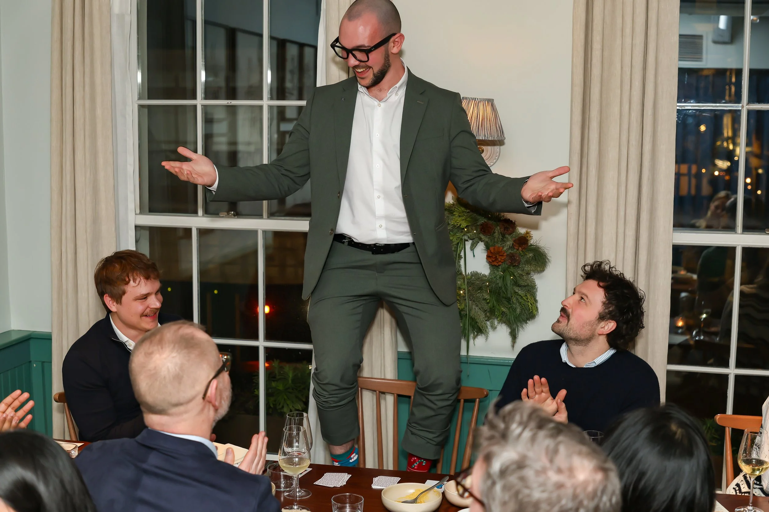 Playful close-up magic creating memorable reactions among guests at a corporate dinner.