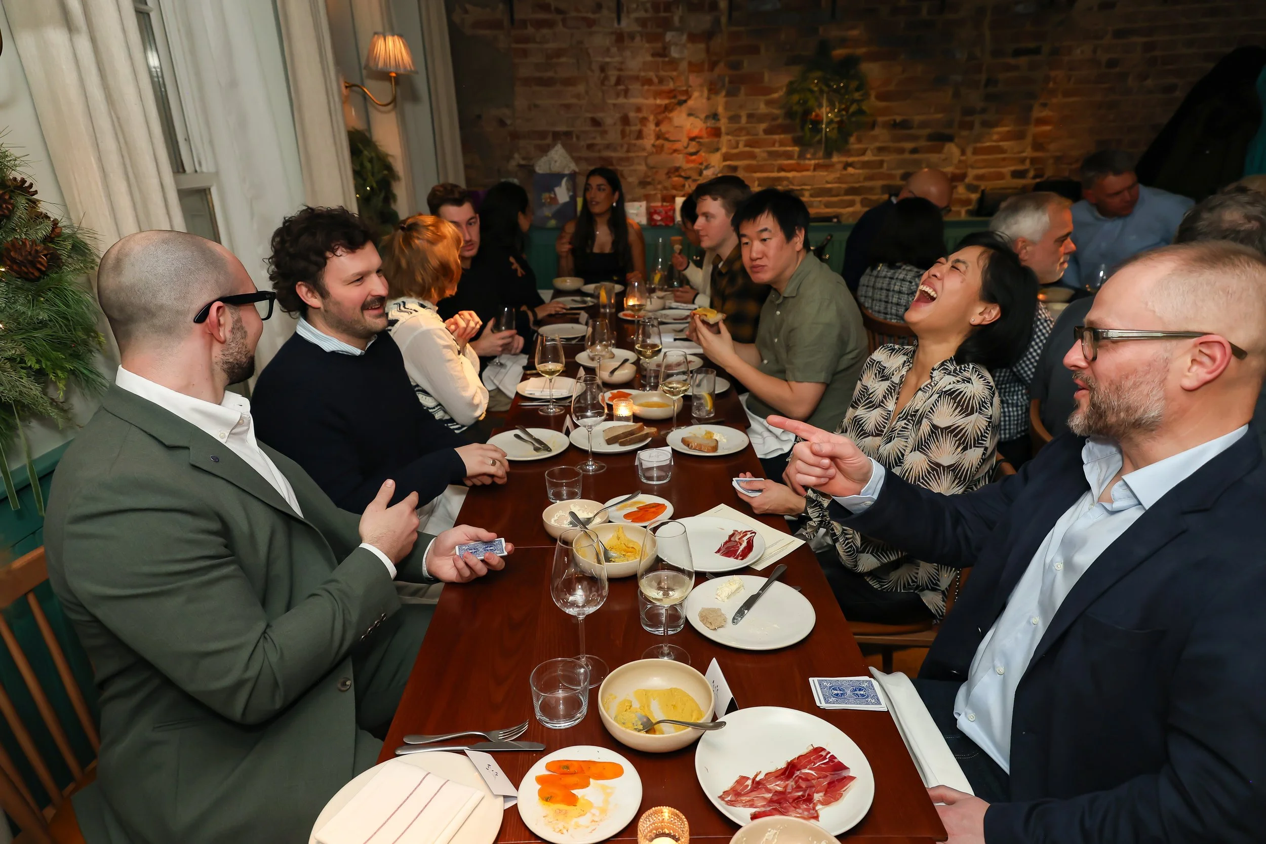 Corporate guests enjoying hands-on magic entertainment during the dinner event.
