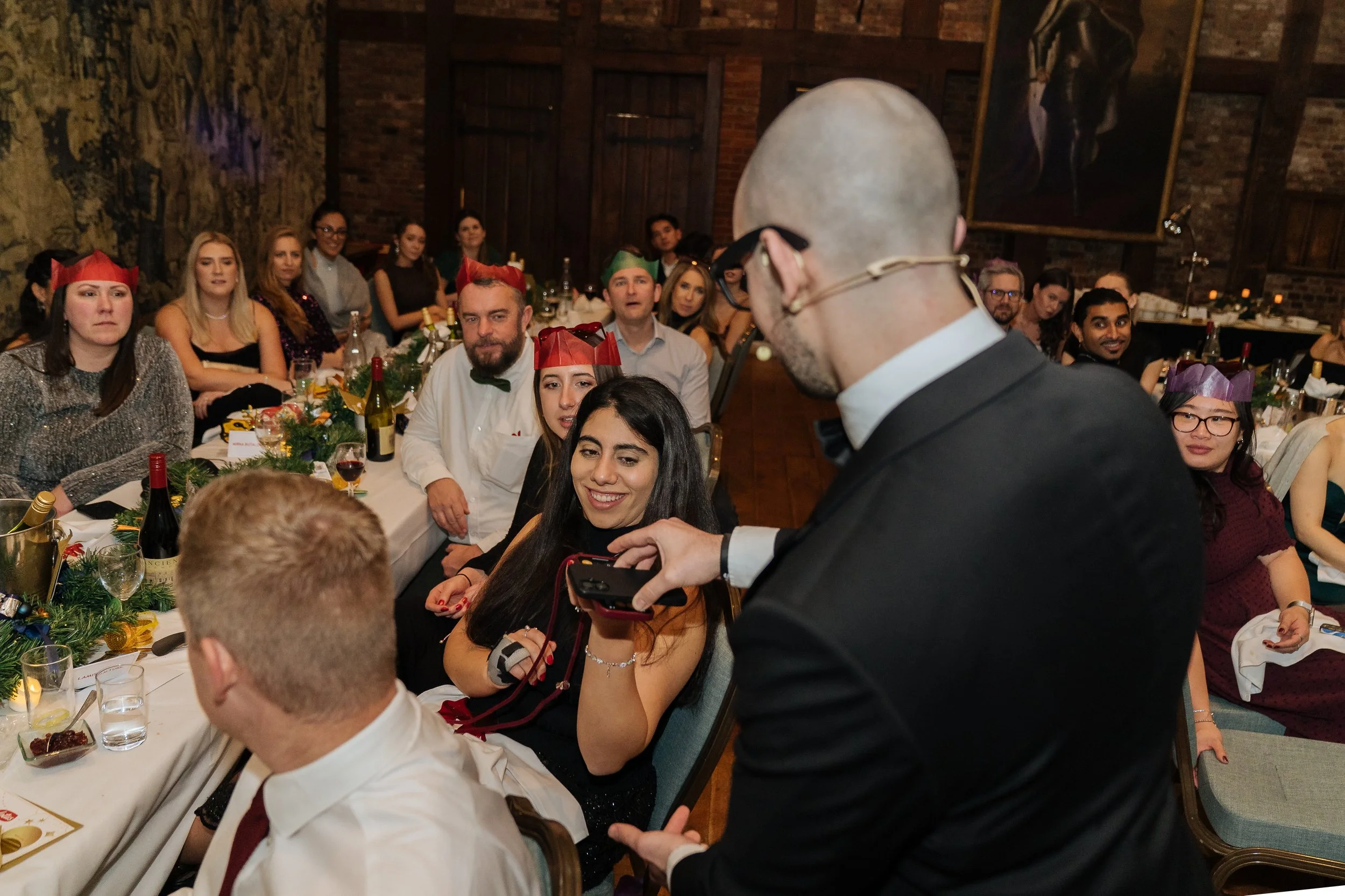 Corporate magician performing table-side magic for guests during a company gala dinner.