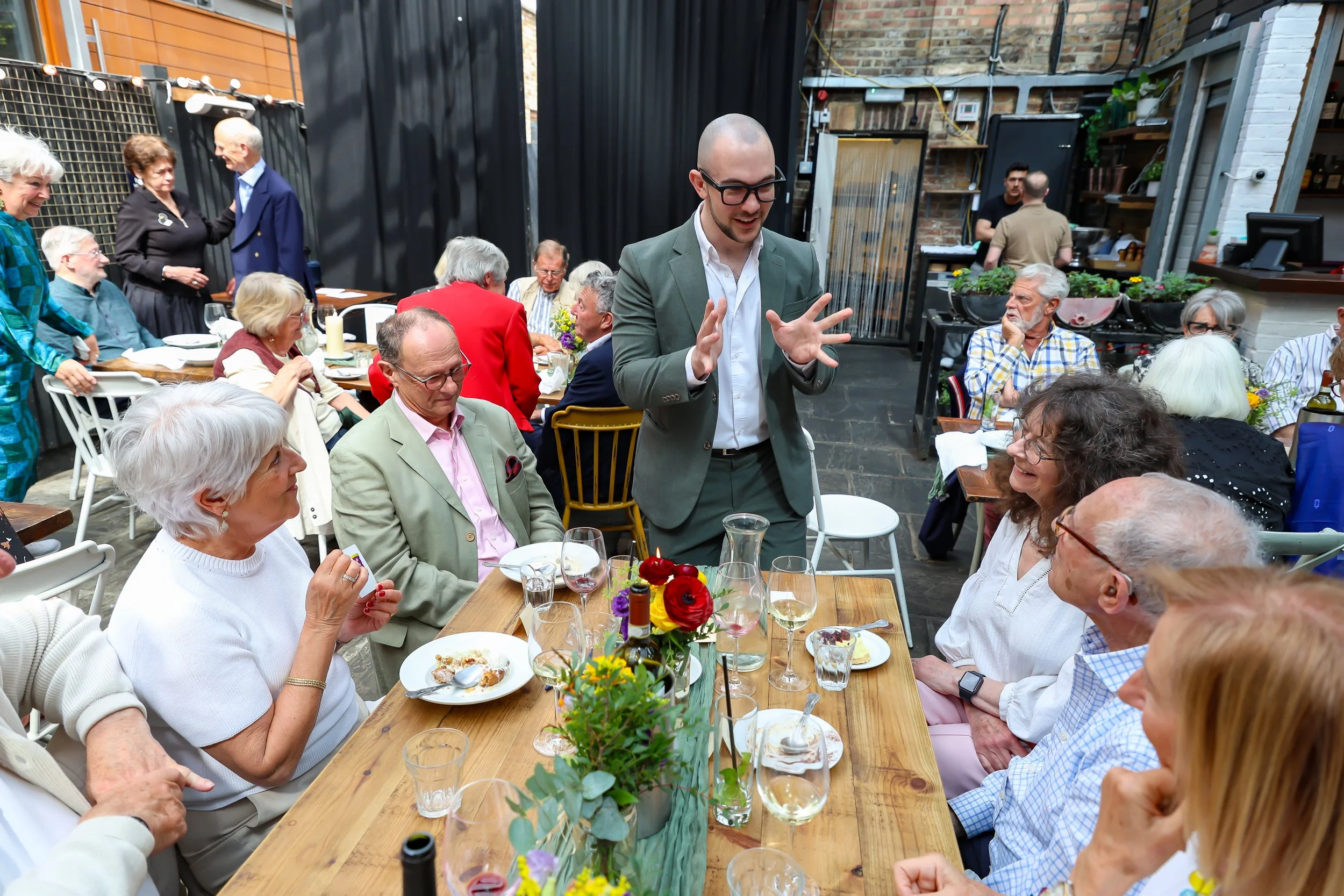 Guests enjoying the time with the Magician card tricks. 2026-May 3 Rhoda & Baruch Golden Anniversary. 