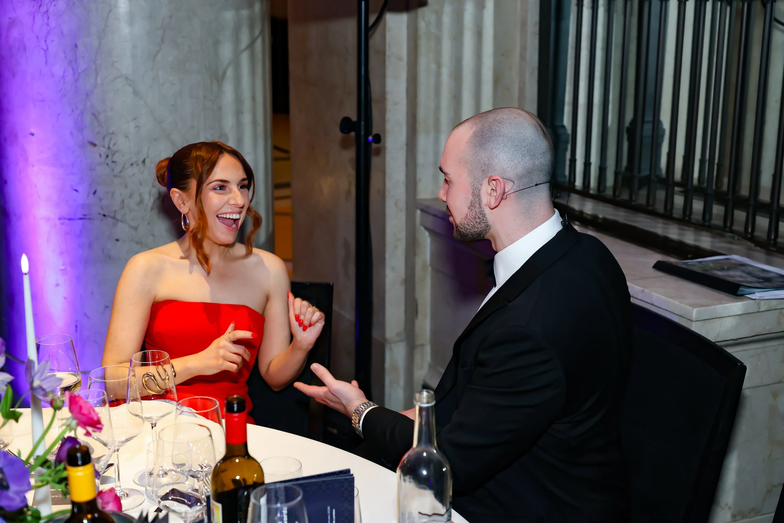 A magician interacting directly with guests, performing magic at the table.