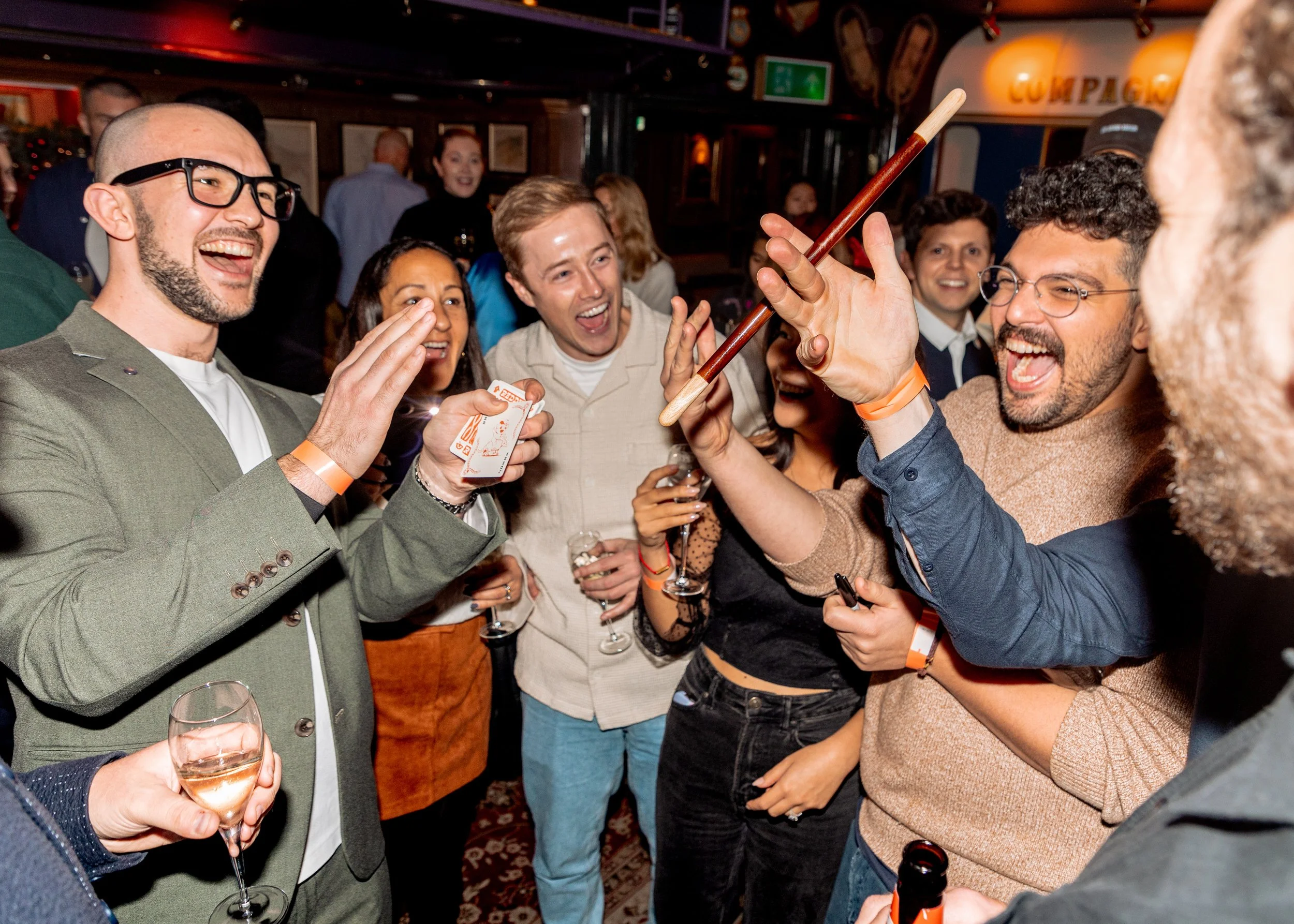 Employees enjoying interactive magic tricks at corporate Christmas gathering.