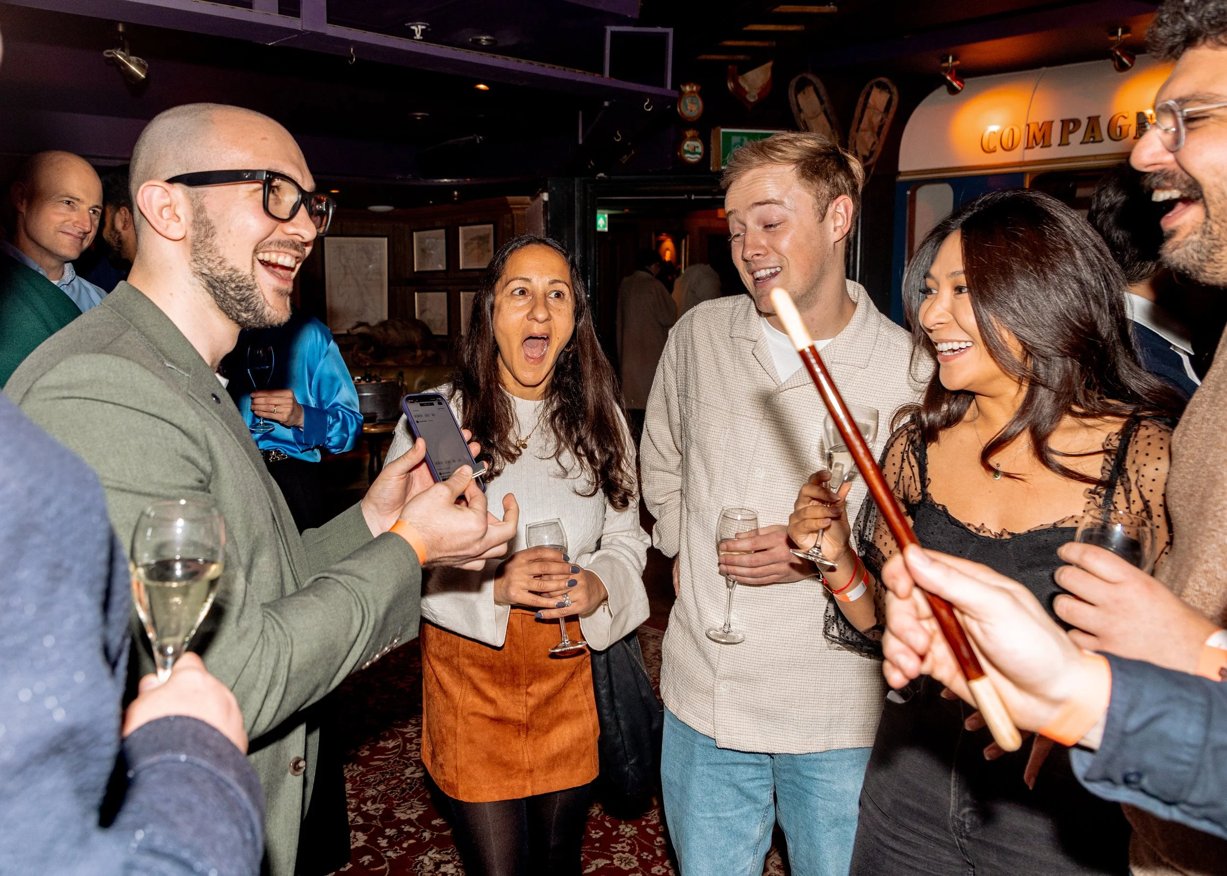 Corporate guests reacting to a mind-blowing magic trick.