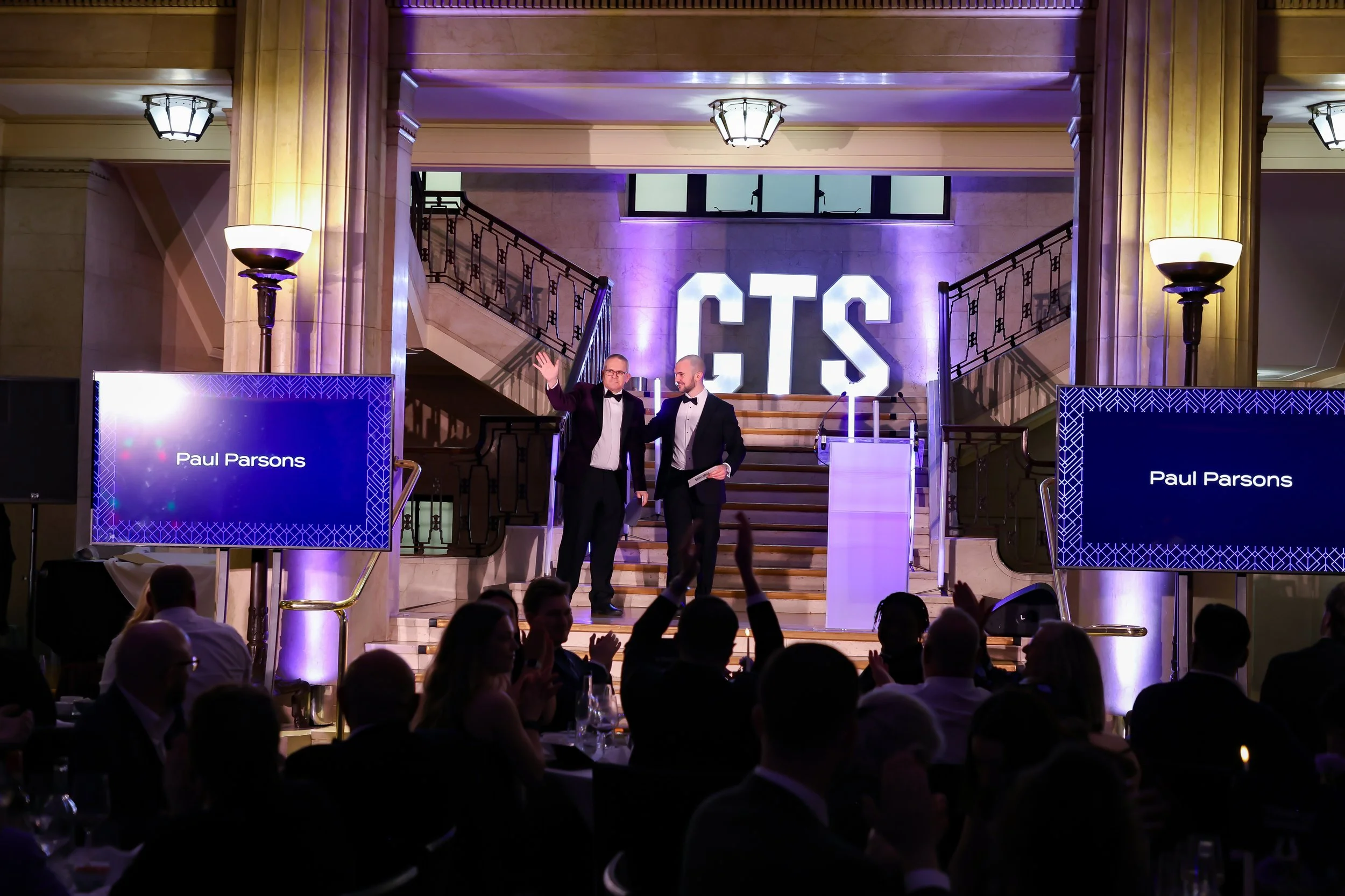 A professional magician involving a guest on stage as the crowd watches in anticipation.