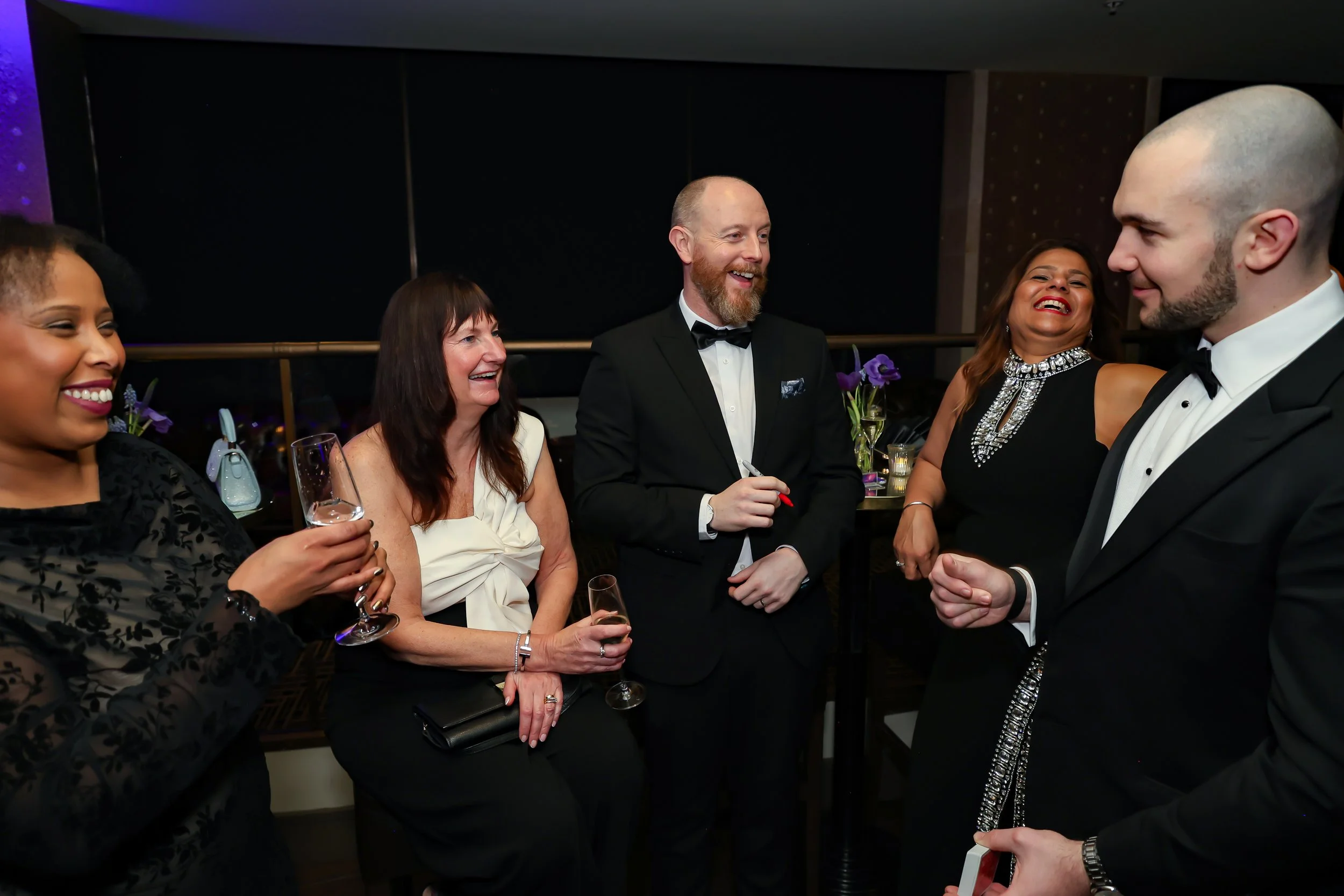 Corporate professionals enjoying with a live card performance by the magician during reception.