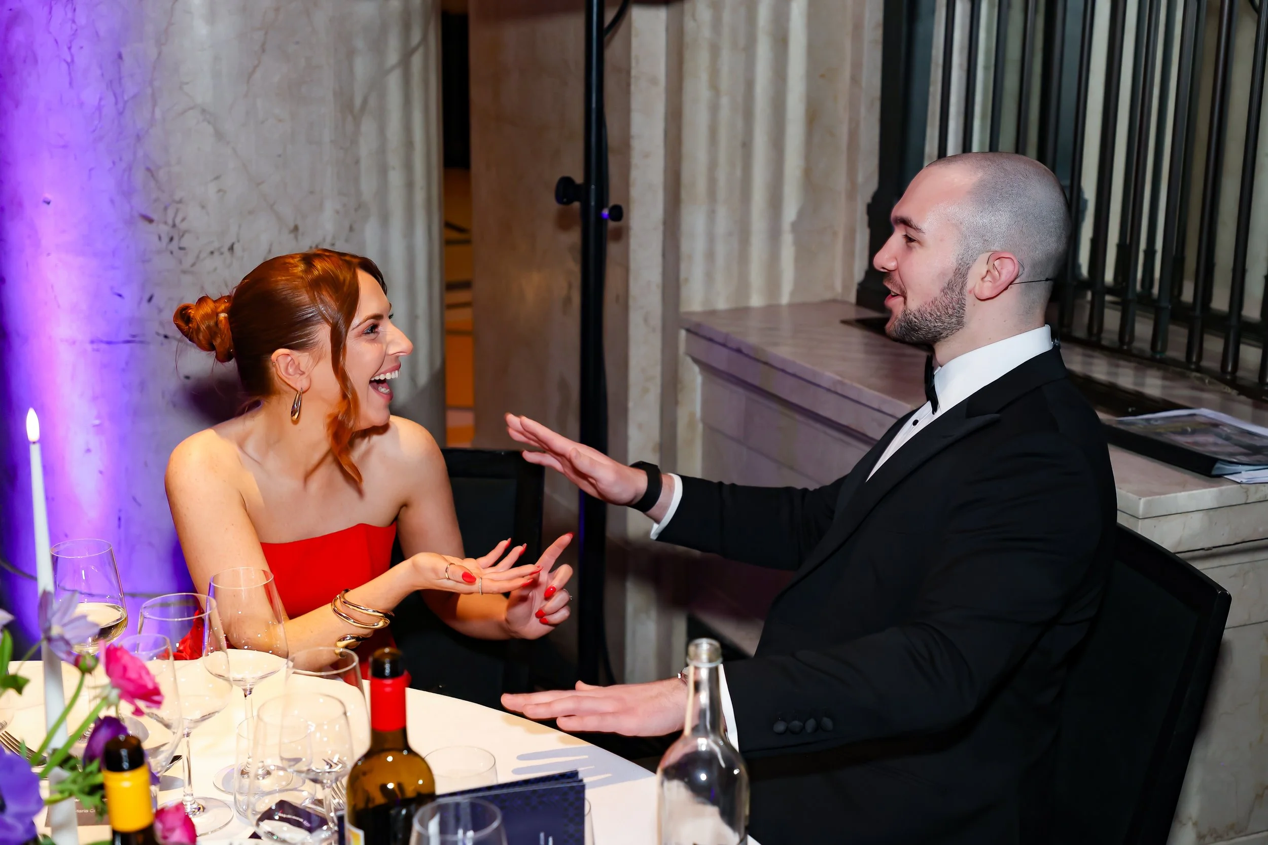 A magician interacting directly with guests, performing magic at the table.