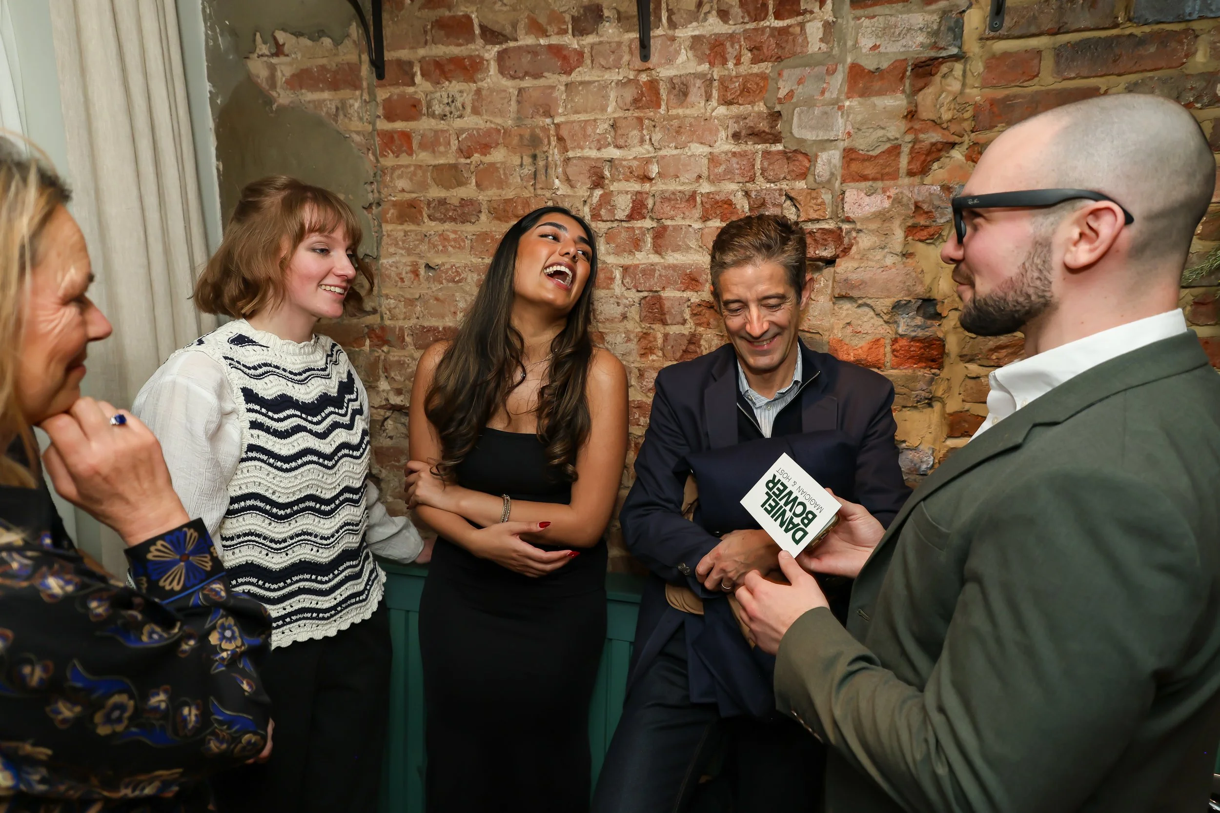 Magician wrapping up an engaging corporate party surrounded by happy guests.