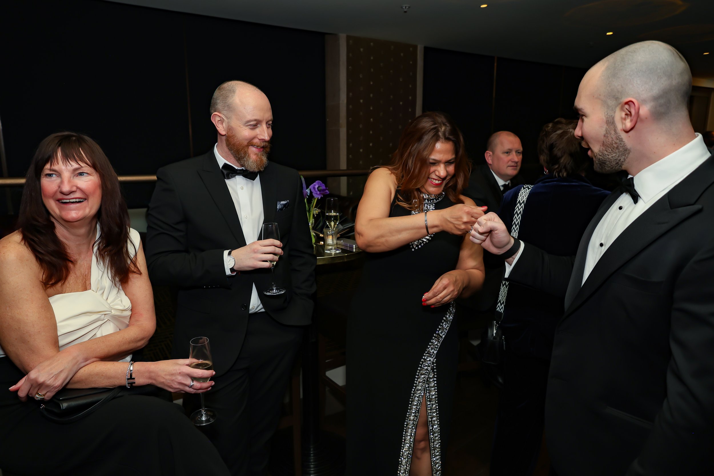 Magician engaging corporate professionals enjoying with a live card performance.