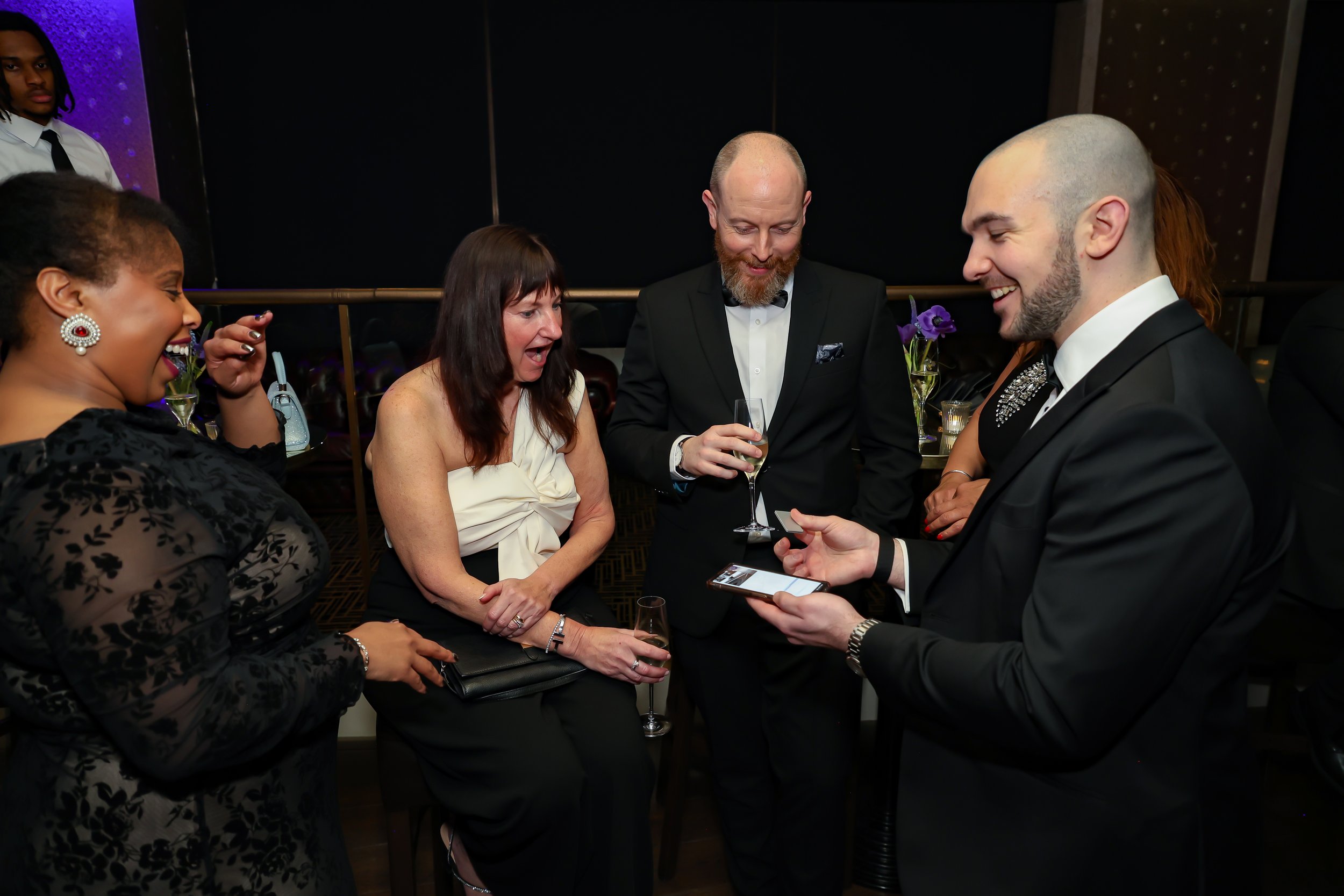 Magician engaging corporate professionals with a live card performance.
