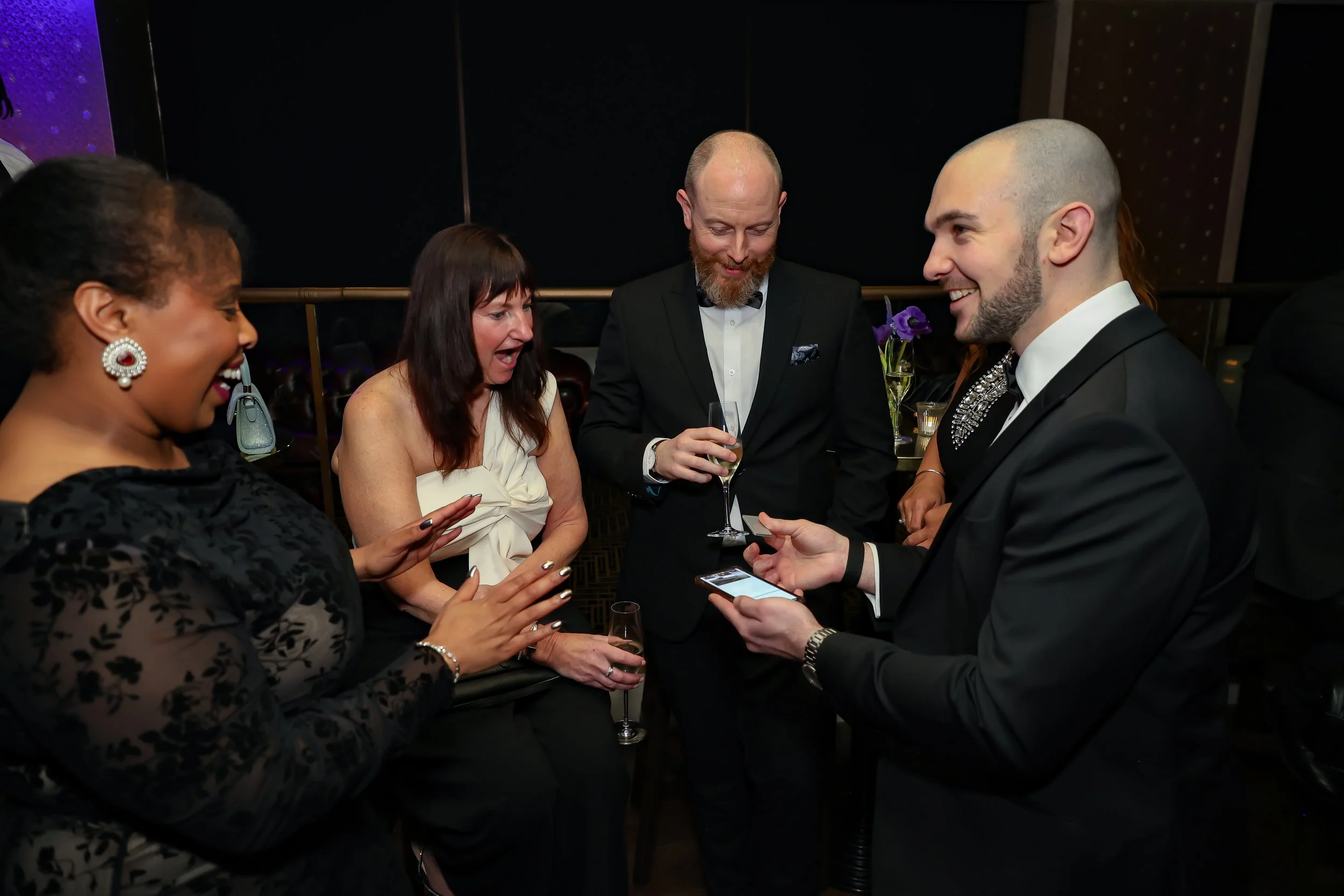 Magician engaging corporate professionals with a live card performance.