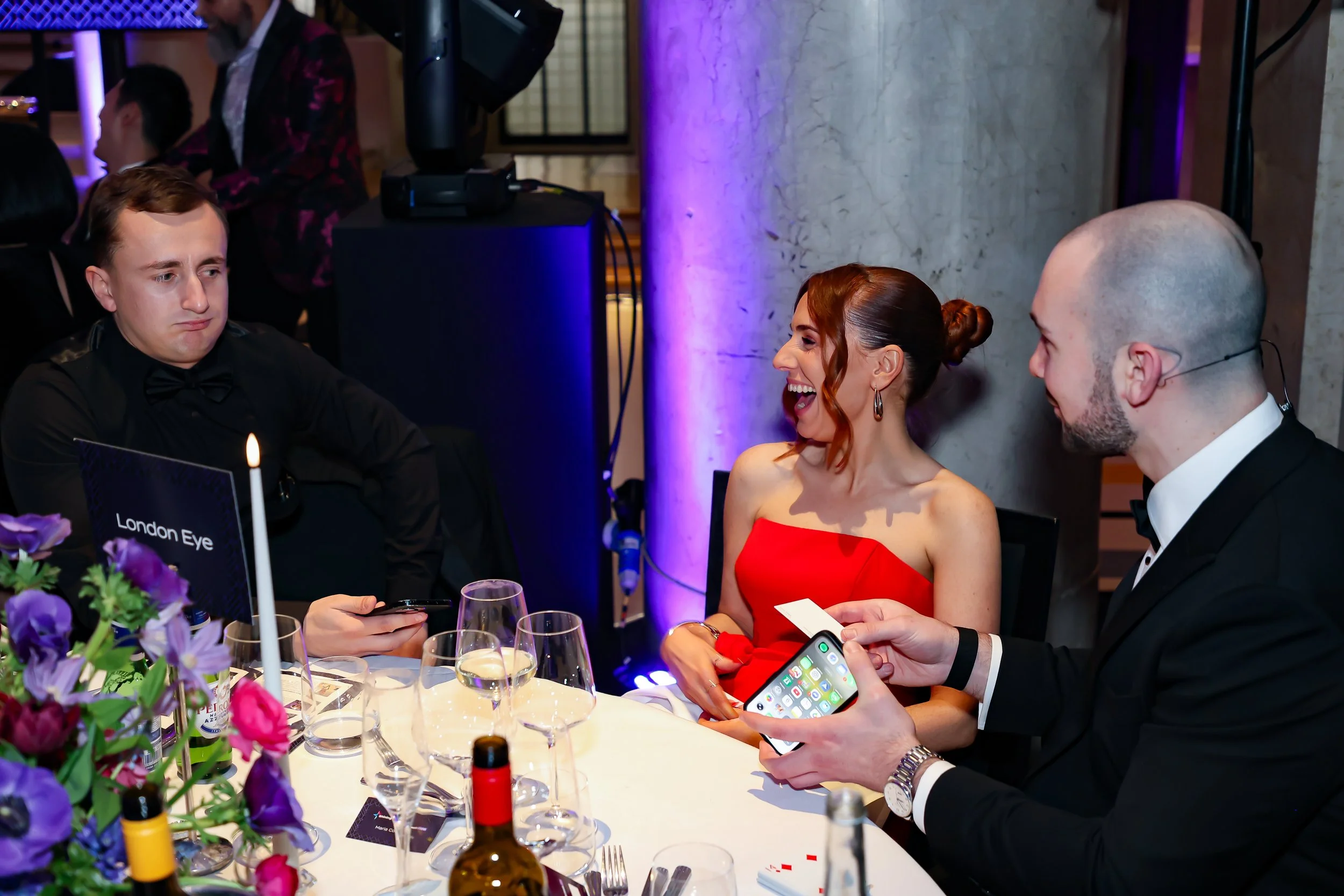 A magician interacting directly with guests, performing magic at the table.