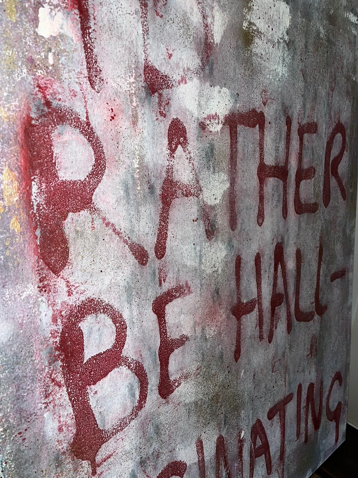 Graffiti on a weathered wall that reads 'PAT HELL BE'. The text appears to be spray painted in red on a gray background with uneven textures.